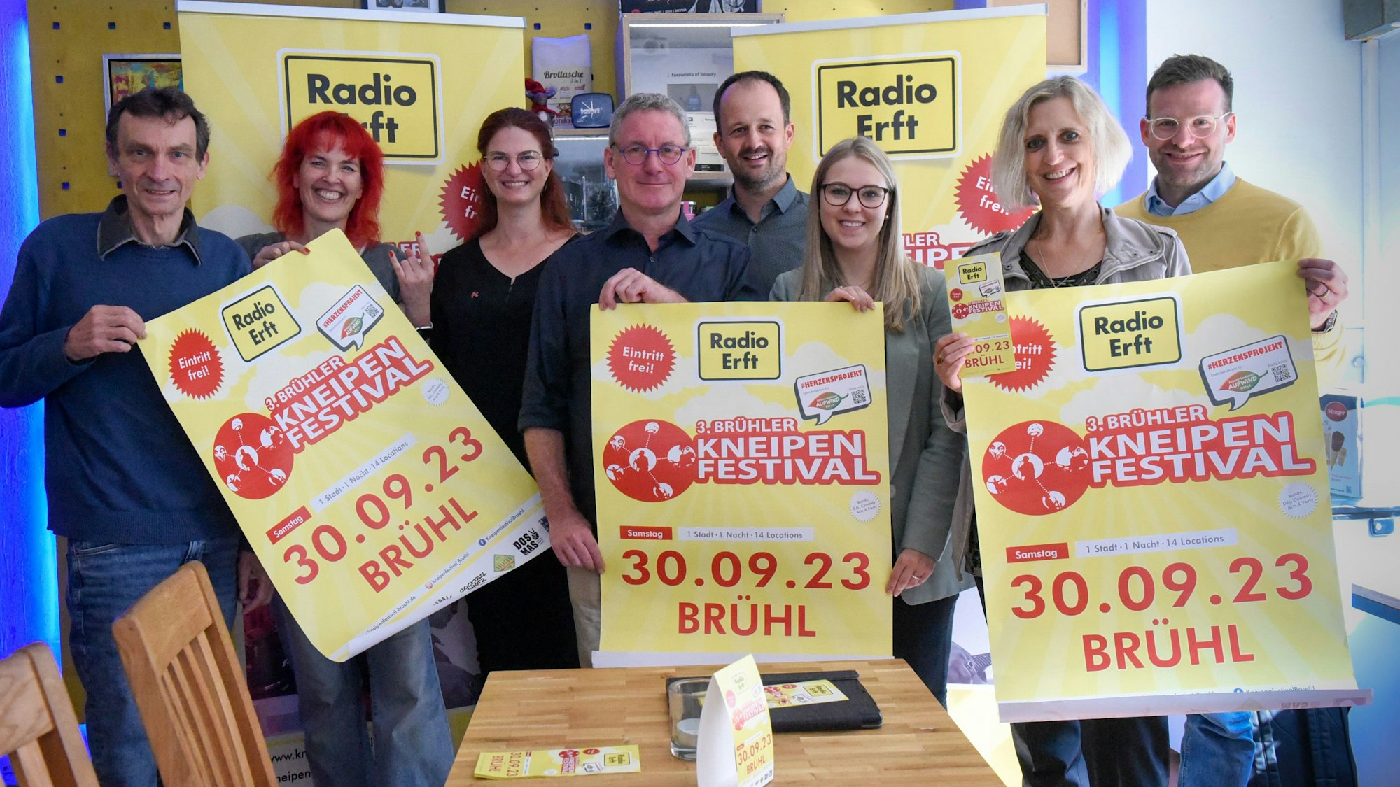 Das Bild zeigt die Organisatoren, die Plakate mit der Ankündigung des Festivals in den Händen halten.