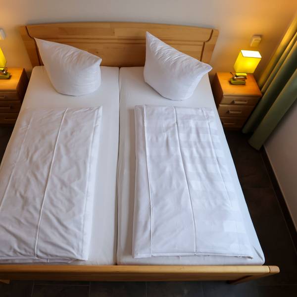 Eine Doppelbett in einem Hotel wurde von oben fotografiert.