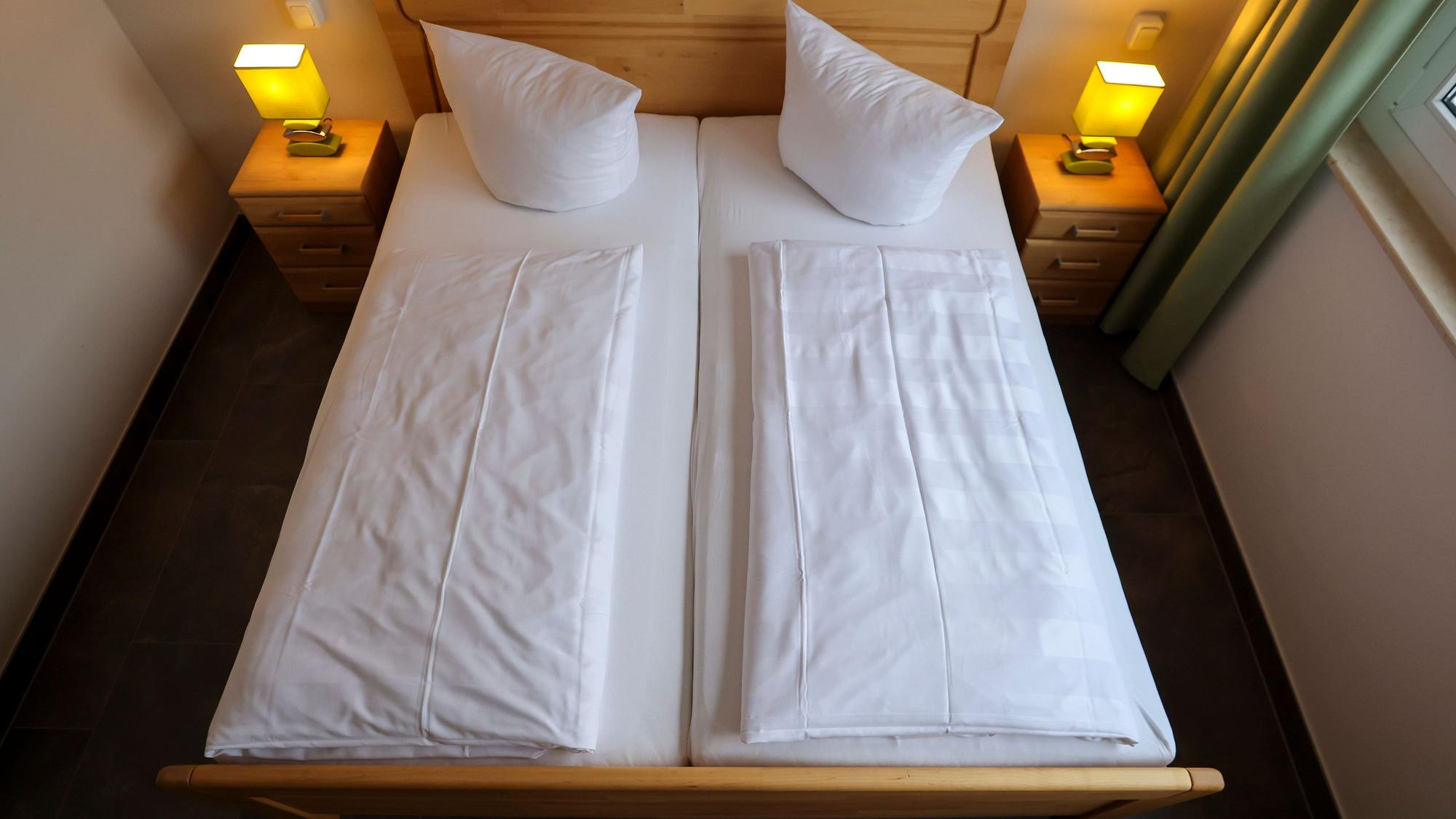 Eine Doppelbett in einem Hotel wurde von oben fotografiert.