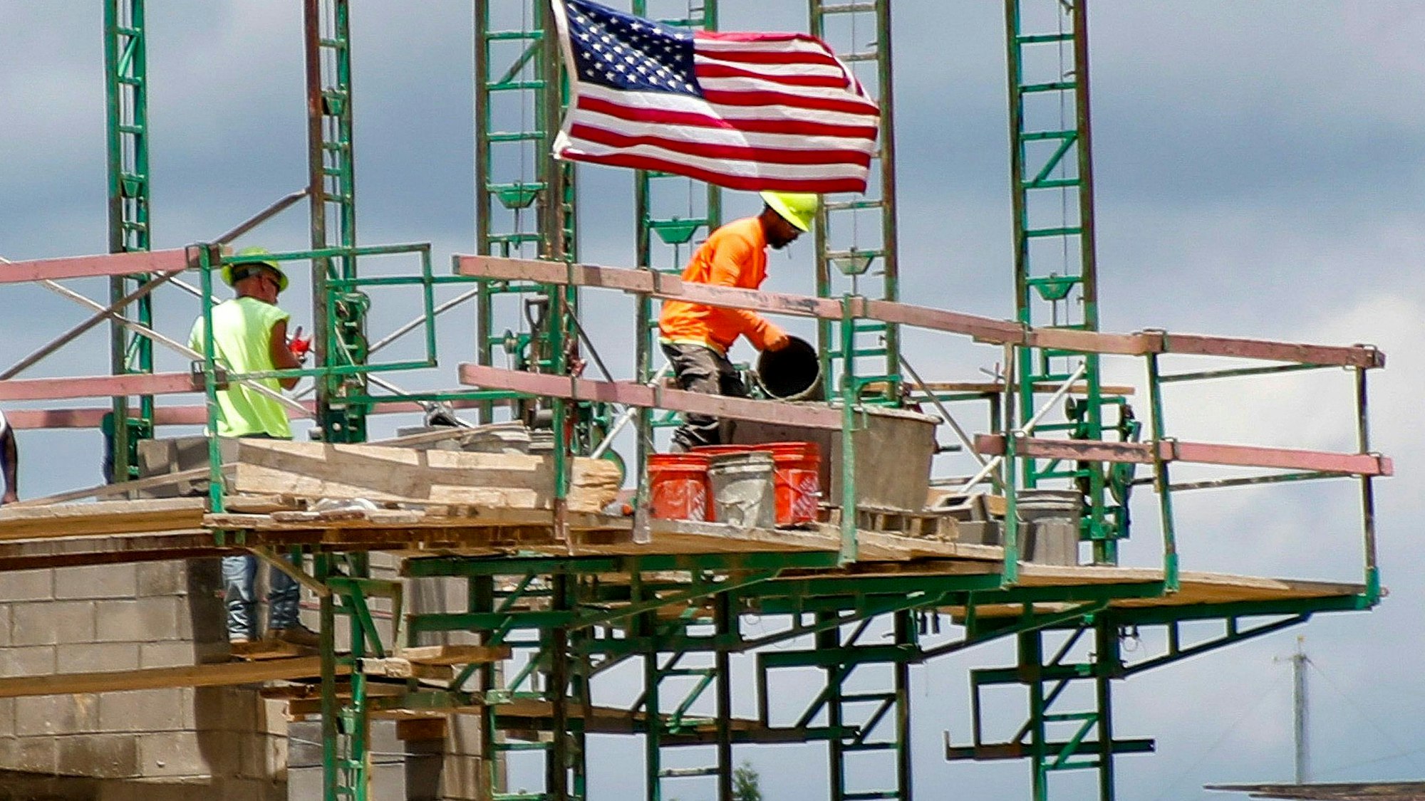ARCHIV - 11.06.2020, USA, Cranberry Township: Bauarbeiter arbeiten auf Gerüsten auf einer Baustelle für Wohn- und Gewerbeeinheiten.