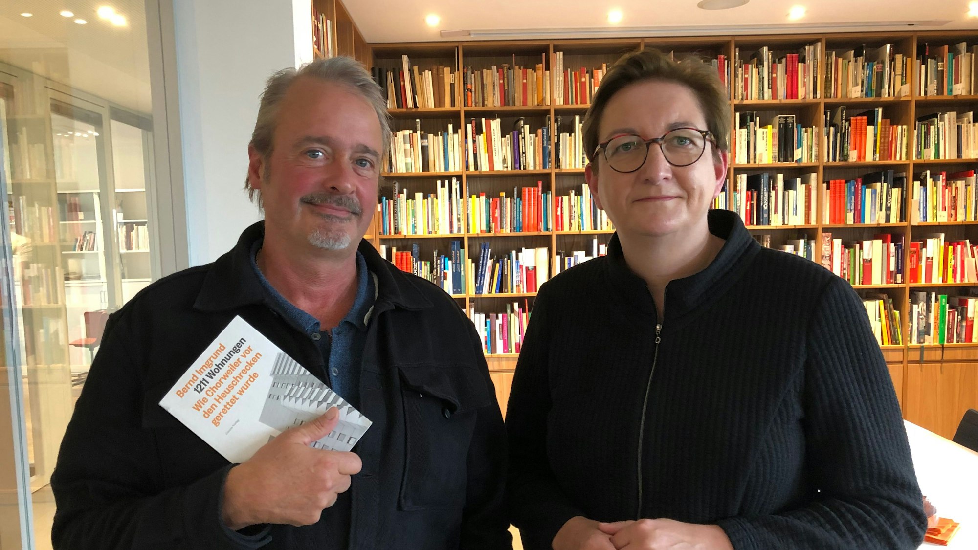 Der Autor und die Bundesbauministerin stehen vor einem Regal mit Büchern.