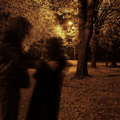 Eine Person greift eine andere Person an einem dunklen Weg an.