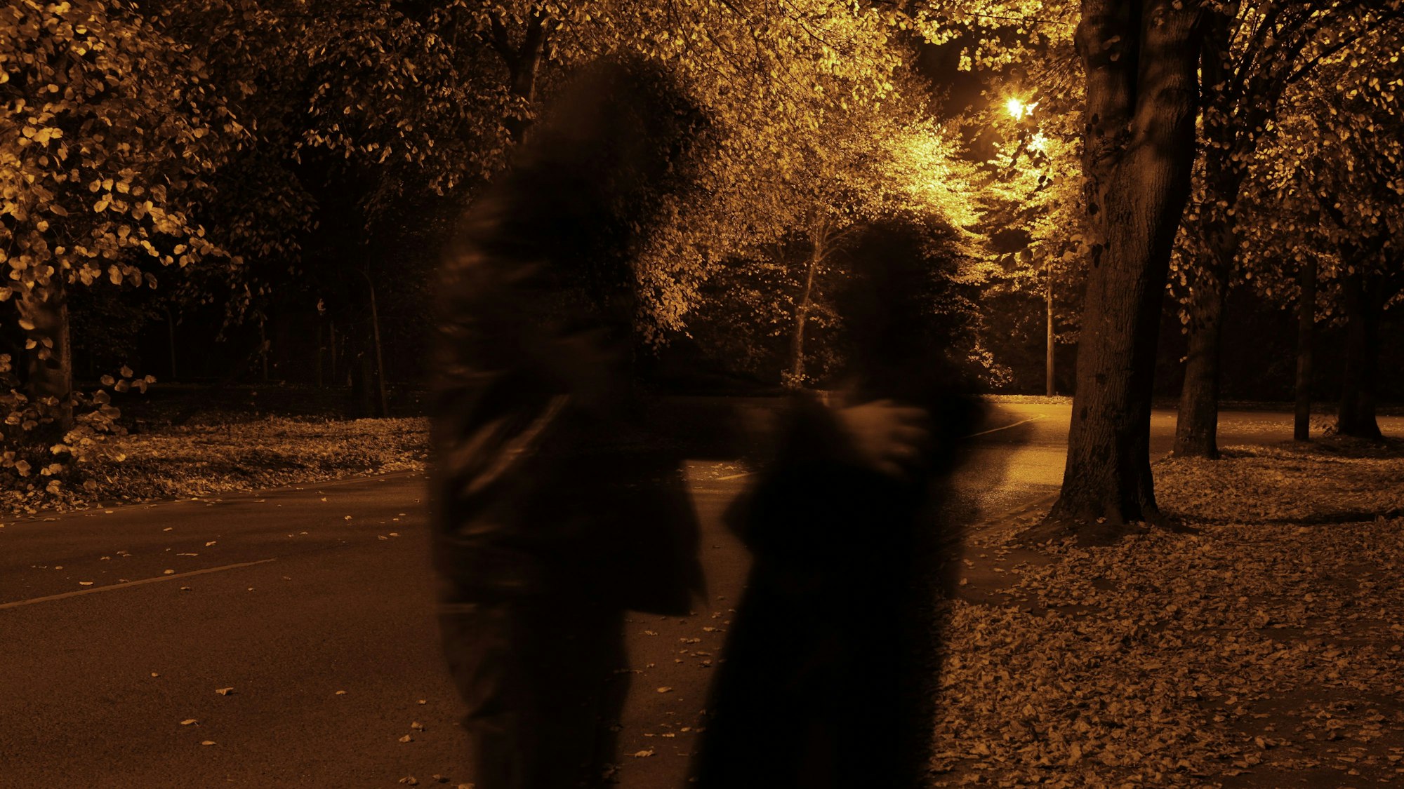 Eine Person greift eine andere Person an einem dunklen Weg an.