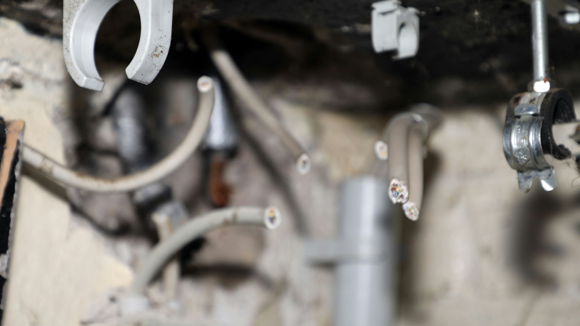 Abgetrennte Kabelenden hängen u8nter der Kellerdecke des Vereinsheims des Schwimmvereins Bergisch Gladbach.