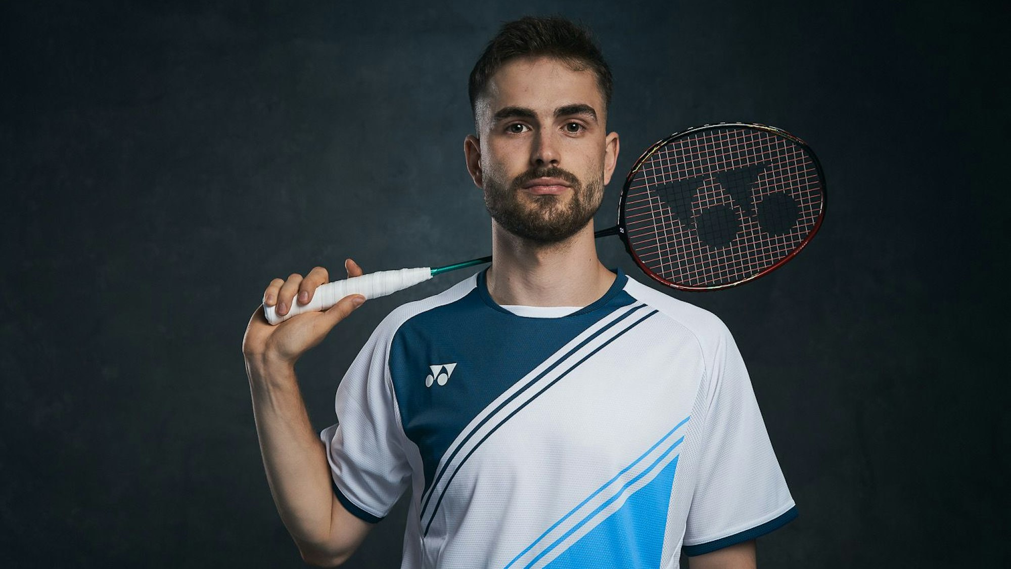 Nationalspieler Jan Colin Völker posiert im Trikot und mit Badmintonschläger