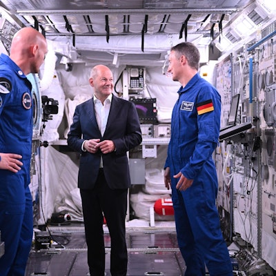Bundeskanzler Olaf Scholz (SPD, M) steht mit den deutschen ESA-Astronauten Matthias Maurer (r) und Alexander Gerst in einem Modell des Columbus-Moduls in der Neutral Bouyancy Facility, während eines Besuchs im Astronautenzentrum der Europäischen Weltraumorganisation ESA.