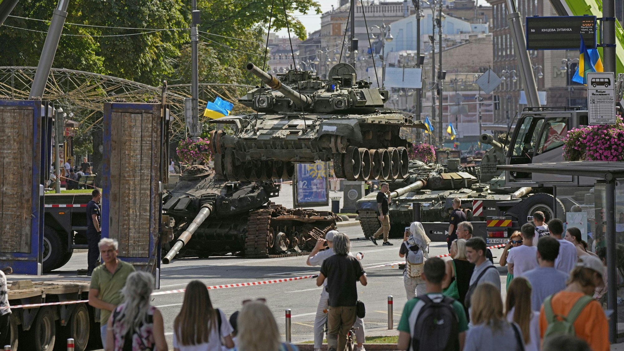 Arbeiter bereiten am 22. August 2023 eine Ausstellung mit erbeuteten russischen Panzern auf einer Straße in Kiew vor.