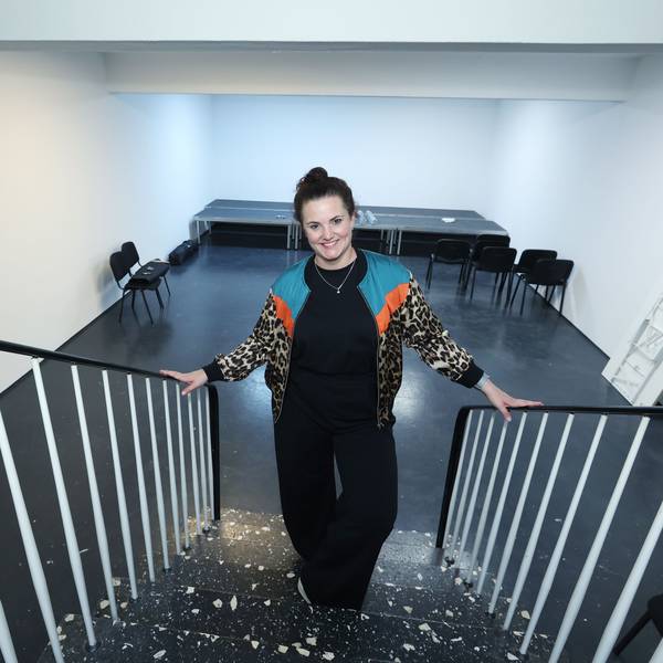 Lene Breuer steht auf der Treppe, hinter ihr die Bühne und vereinzelte Stühle davor.