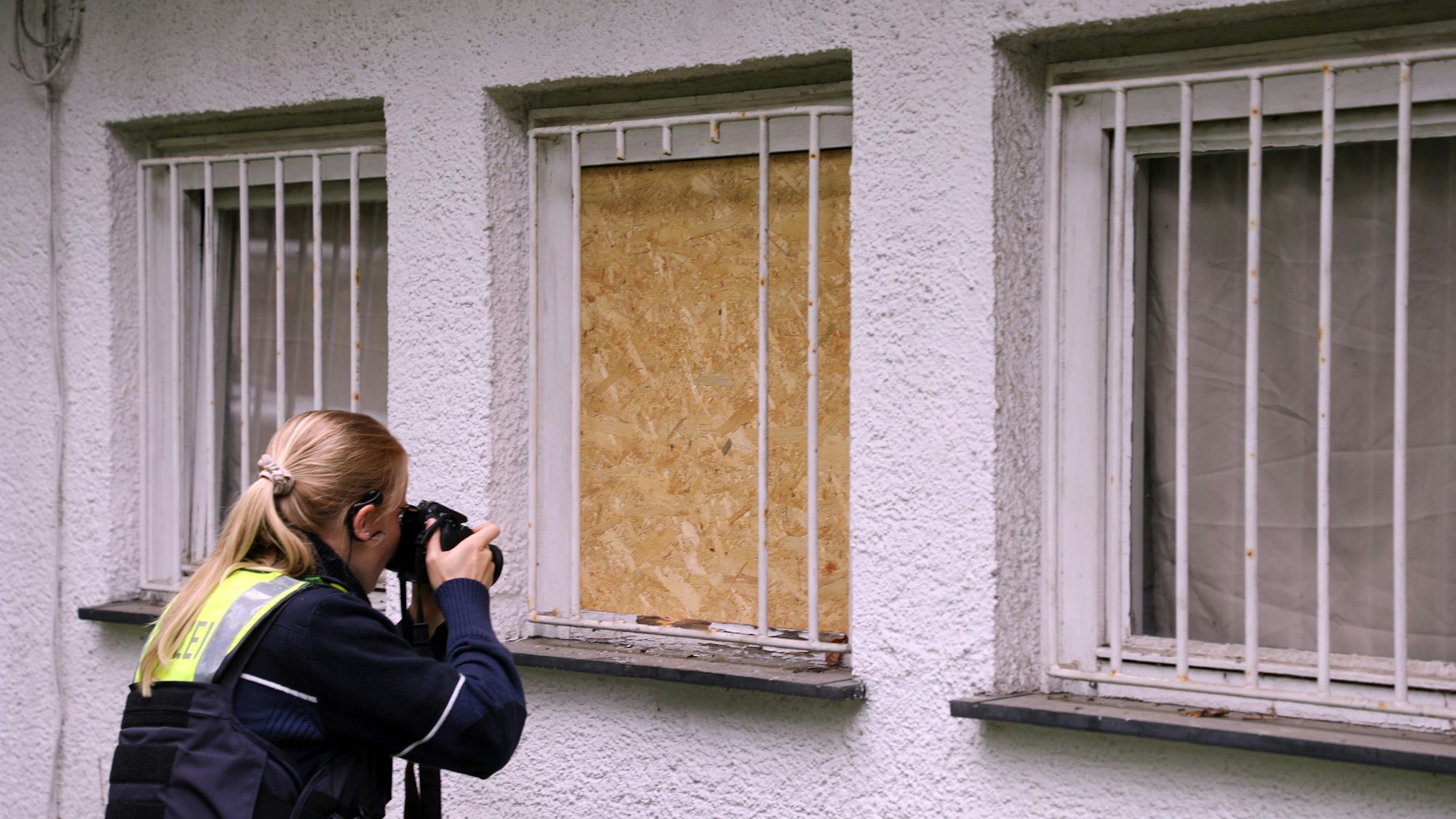 Eine Polizeibeamtin fotografiert Einbruchpuren am Vereinsheim des Schwimmvereins Bergisch Gladbach.