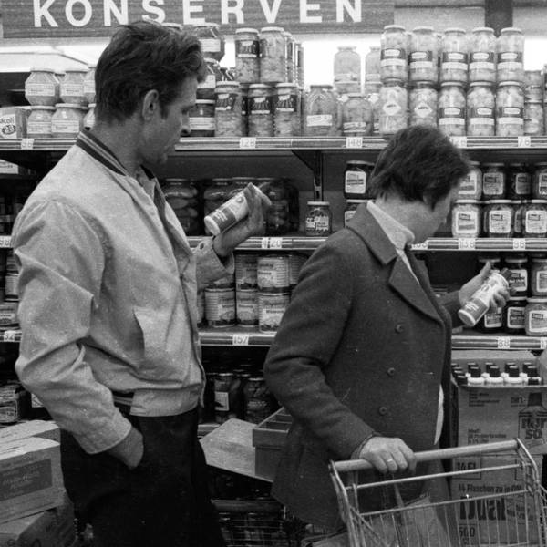 Kunden stehen an einem Regal im Supermarkt.