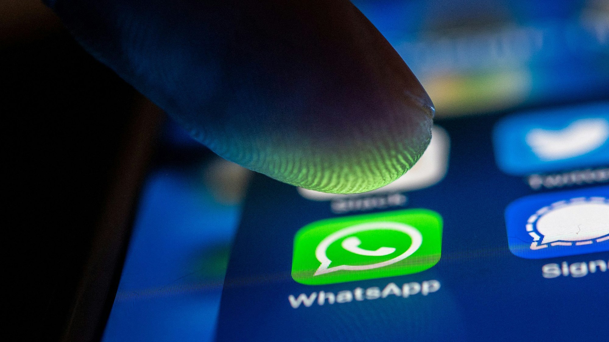 Ein Finger berührt das WhatsApp-Logo auf einem Smartphone. (Symbolbild)