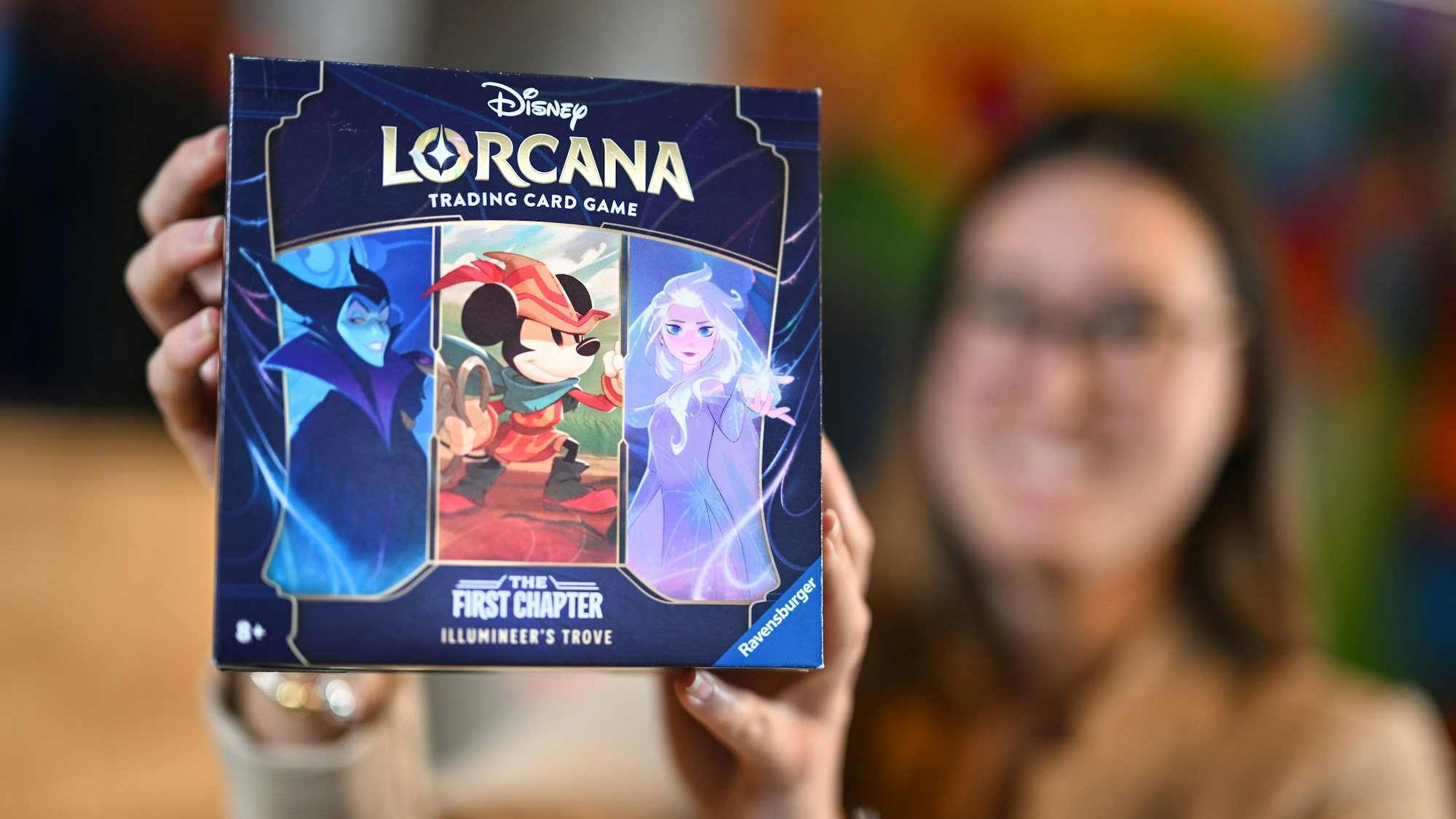 Eine Mitarbeiterin des Spieleherstellers Ravensburger AG hält das neue Sammelkartenspiel Disney Lorcana Trading Card Game, The First Chapter in den Händen.