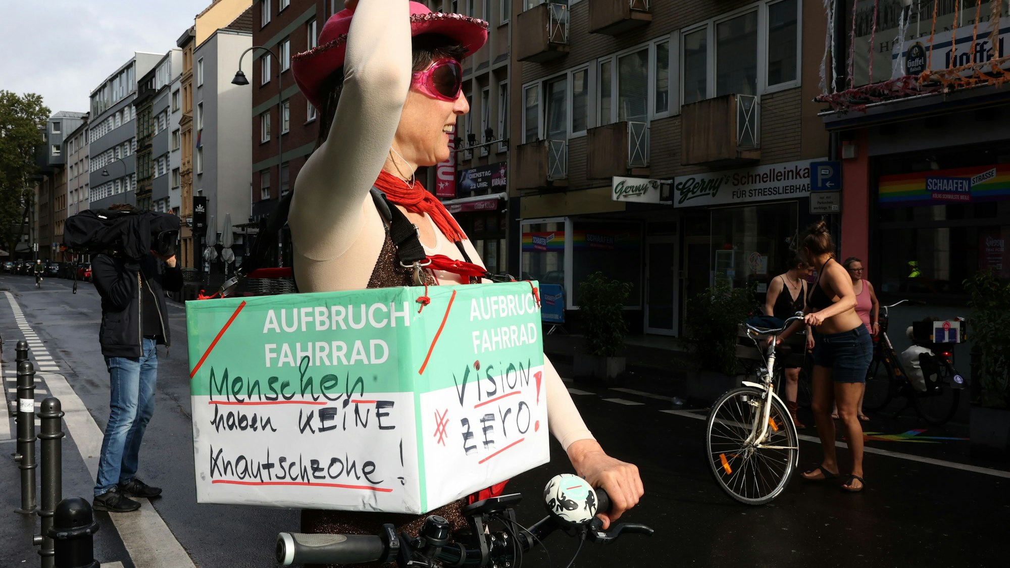 Eine verkleidete Frau trägt ein Demo-Schild um den Bauch.