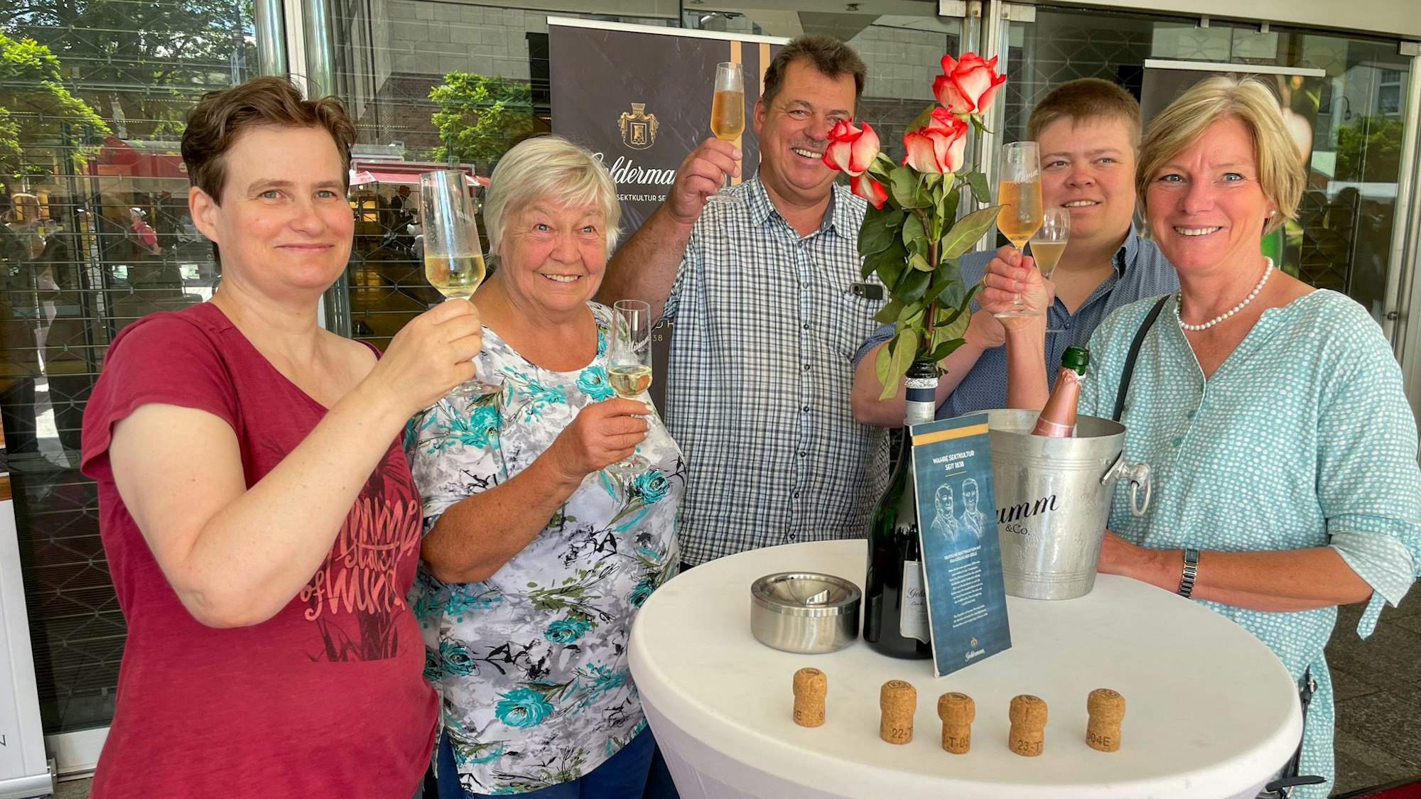 Sektstand: Einige Menschen stoßen an.