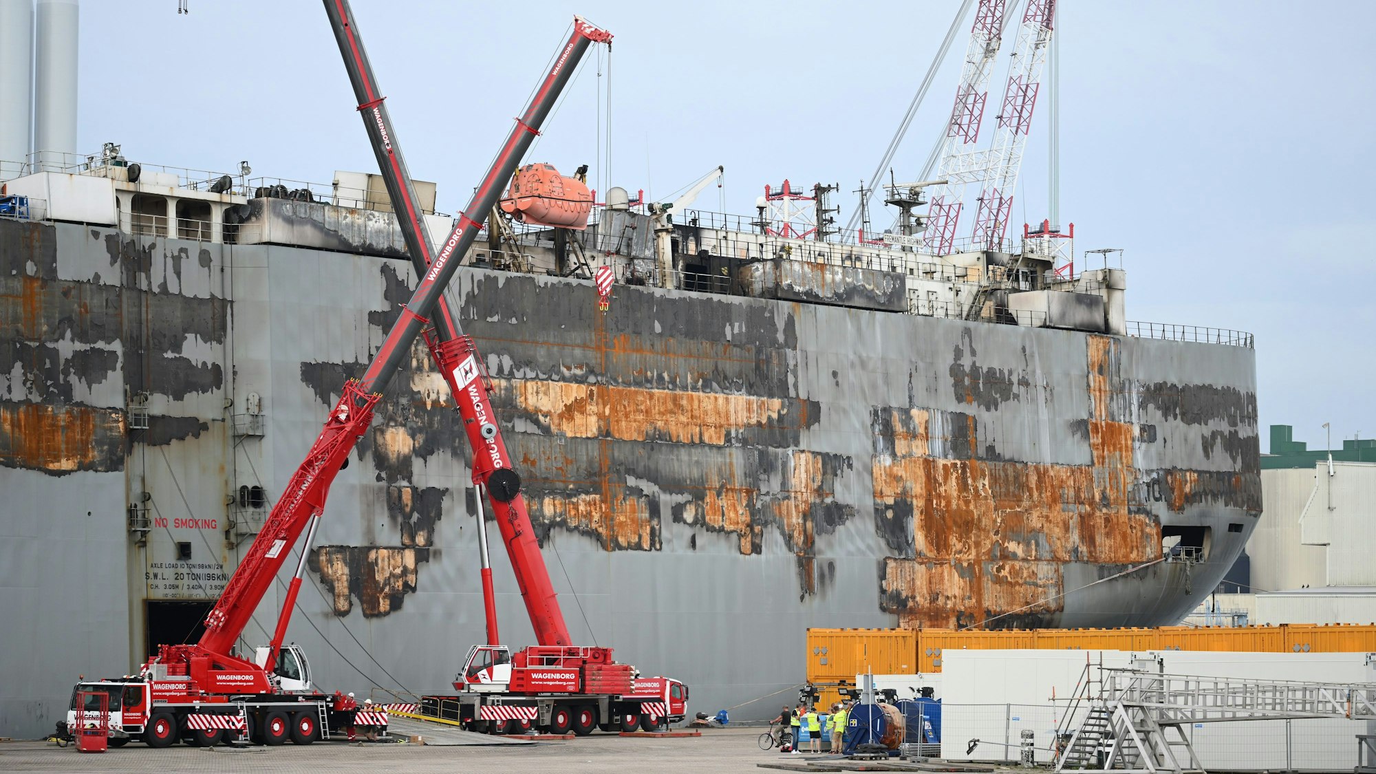 Mehrere Kräne stehen vor dem havarierten Nordsee-Frachter „Fremantle Highway“, der im Wattenmeer vor Ameland in Brand geraten war. Das Frachtschiff liegt seitdem im Hafen von Eemshaven in den Niederlanden.
