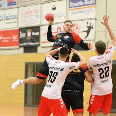 Robin Voiß springt in zwei Gegenspieler und einen Mitspieler hinein.