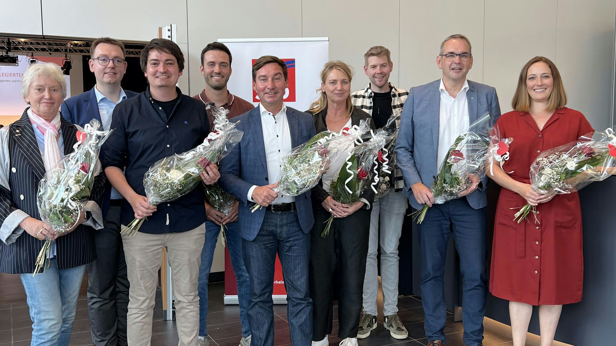 Nach ihrer Wahl haben sich die Mitglieder des SPD-Kreisvorstands um den Vorsitzenden Sebastian Hartmann mit Blumensträußen zum Gruppenfoto aufgestellt.