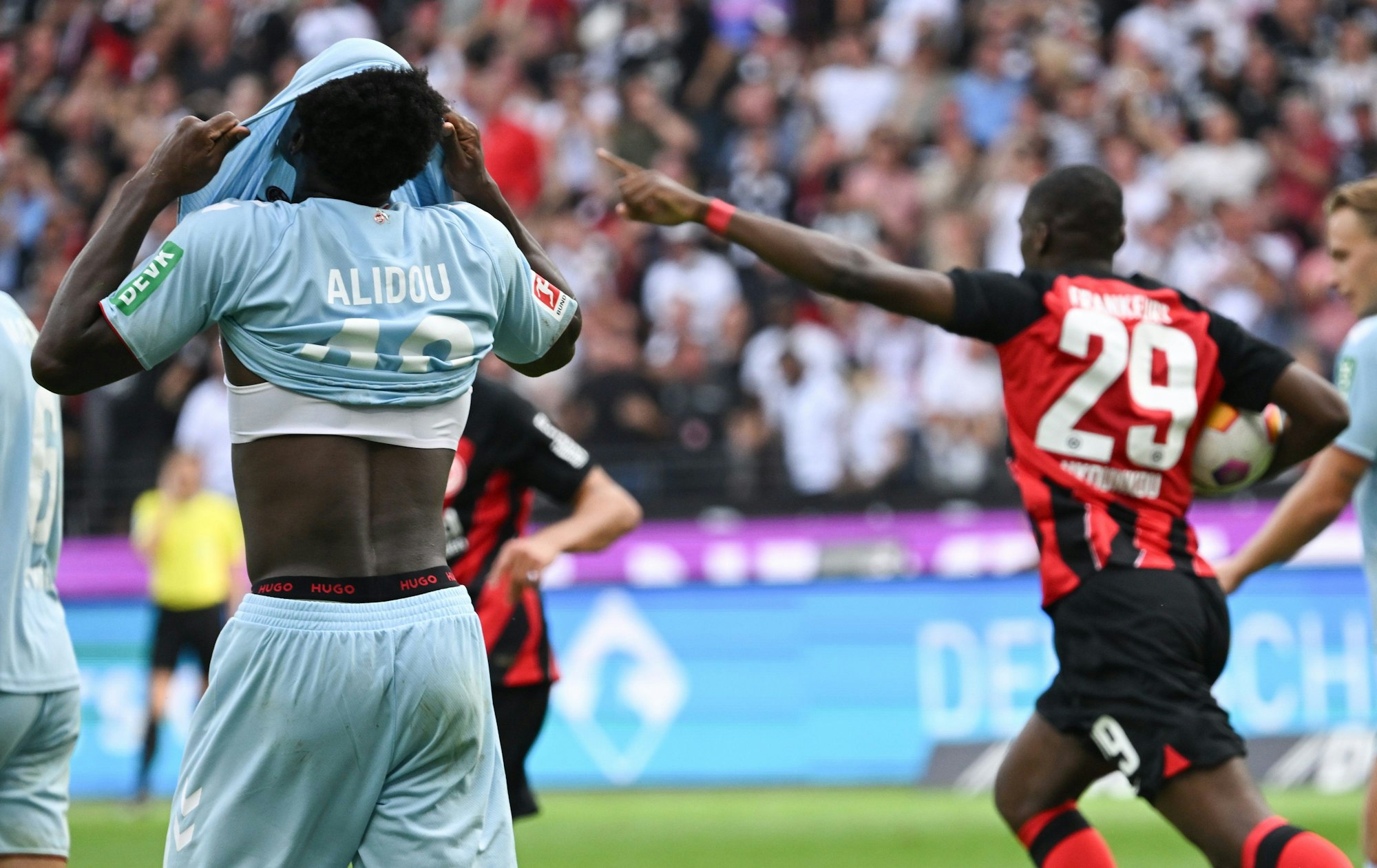 Frankfurts Niels Nkounkou (r.) jubelt nach dem Tor zum 1:1-Ausgleich, während Kölns Faride Alidou gefrustet sein Trikot über den Kopf zieht.