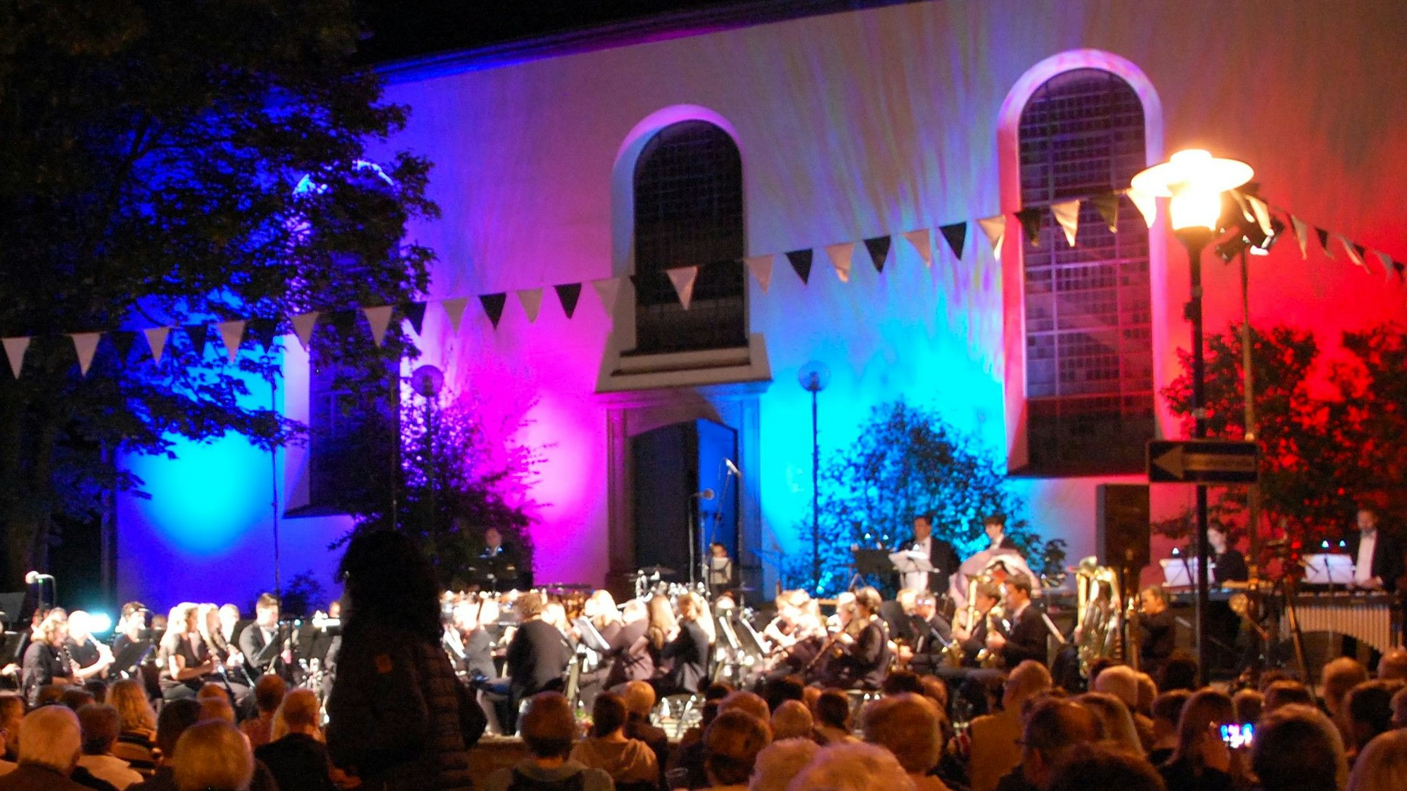 Die bunt beleuchtete Kirchenfassade bei der Burscheider Sommerserenade im September 2023
