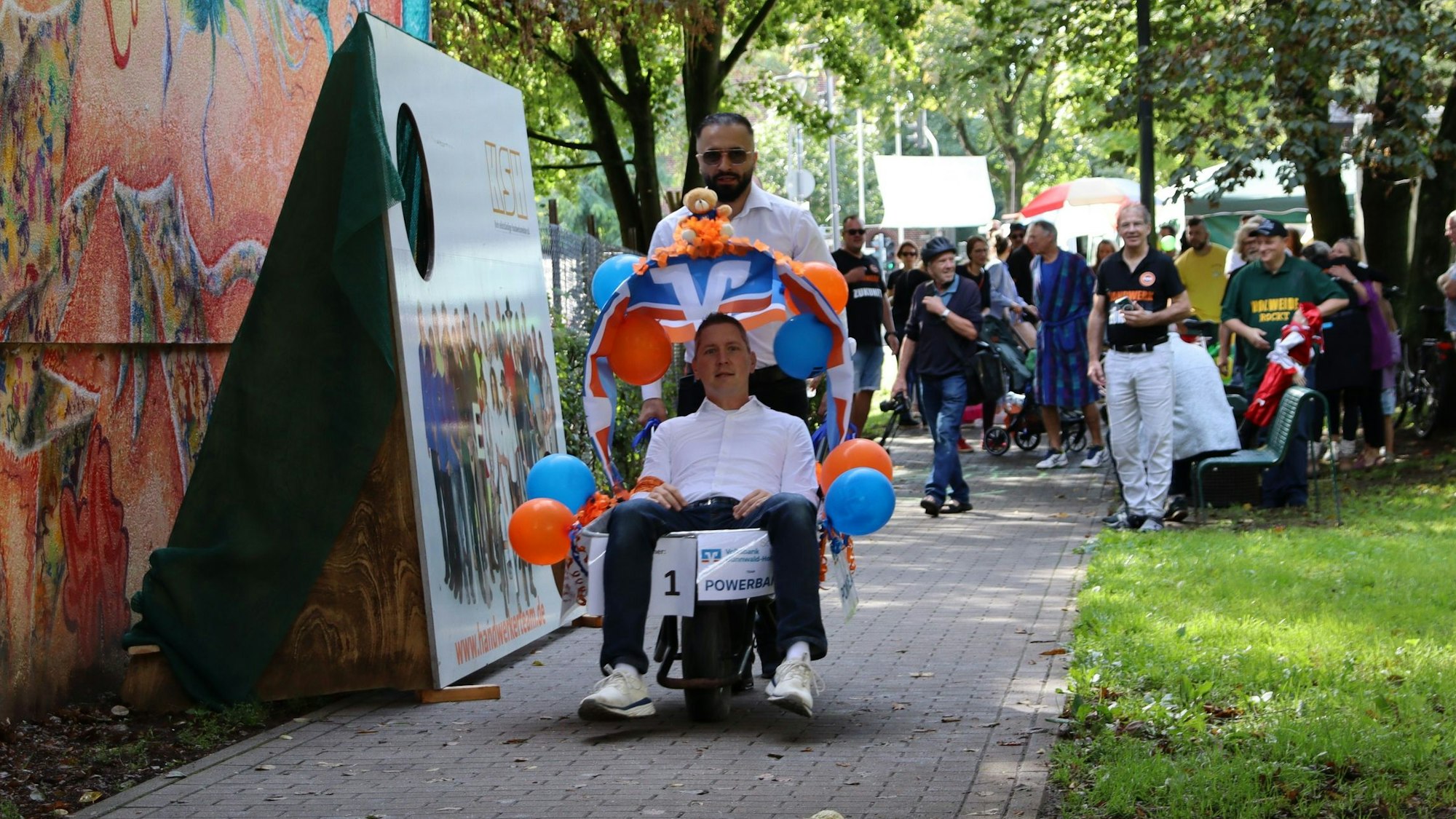 Ein Mann wird in einer Schubkarre gezogen.