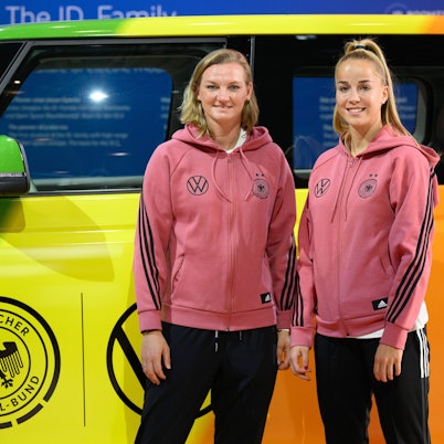 Fußballerinnen Alexandra Popp (links) und Giulia Gwinn vor einem VW bei einer Pressekonferenz im Herbst 2022.