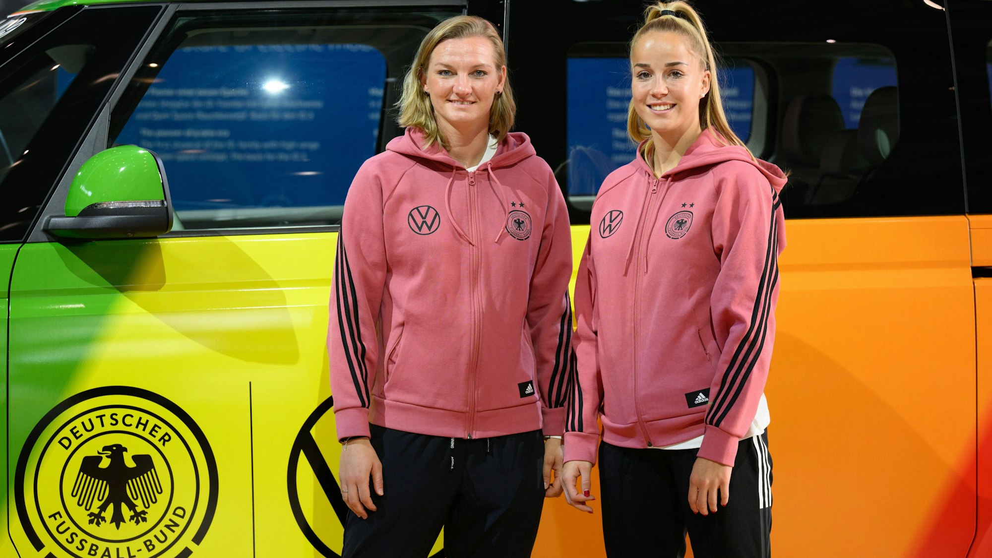 Fußballerinnen Alexandra Popp (links) und Giulia Gwinn vor einem VW bei einer Pressekonferenz im Herbst 2022.