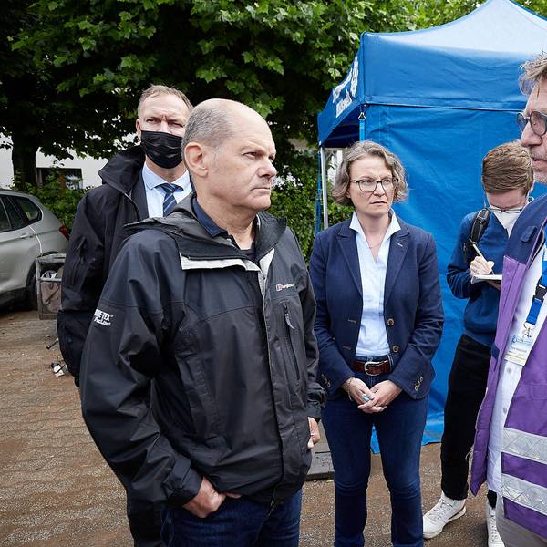 Olaf Scholz und Ina Scharrenbach sprechen mit Frank Waldschmidt. Im Hintergrund steht ein Zelt des Technischen Hilfswerks.