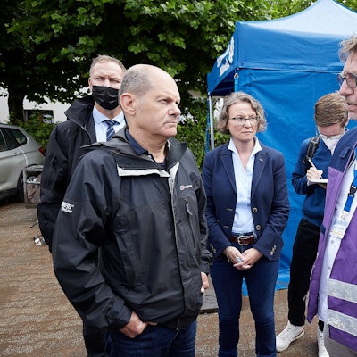 Olaf Scholz und Ina Scharrenbach sprechen mit Frank Waldschmidt. Im Hintergrund steht ein Zelt des Technischen Hilfswerks.