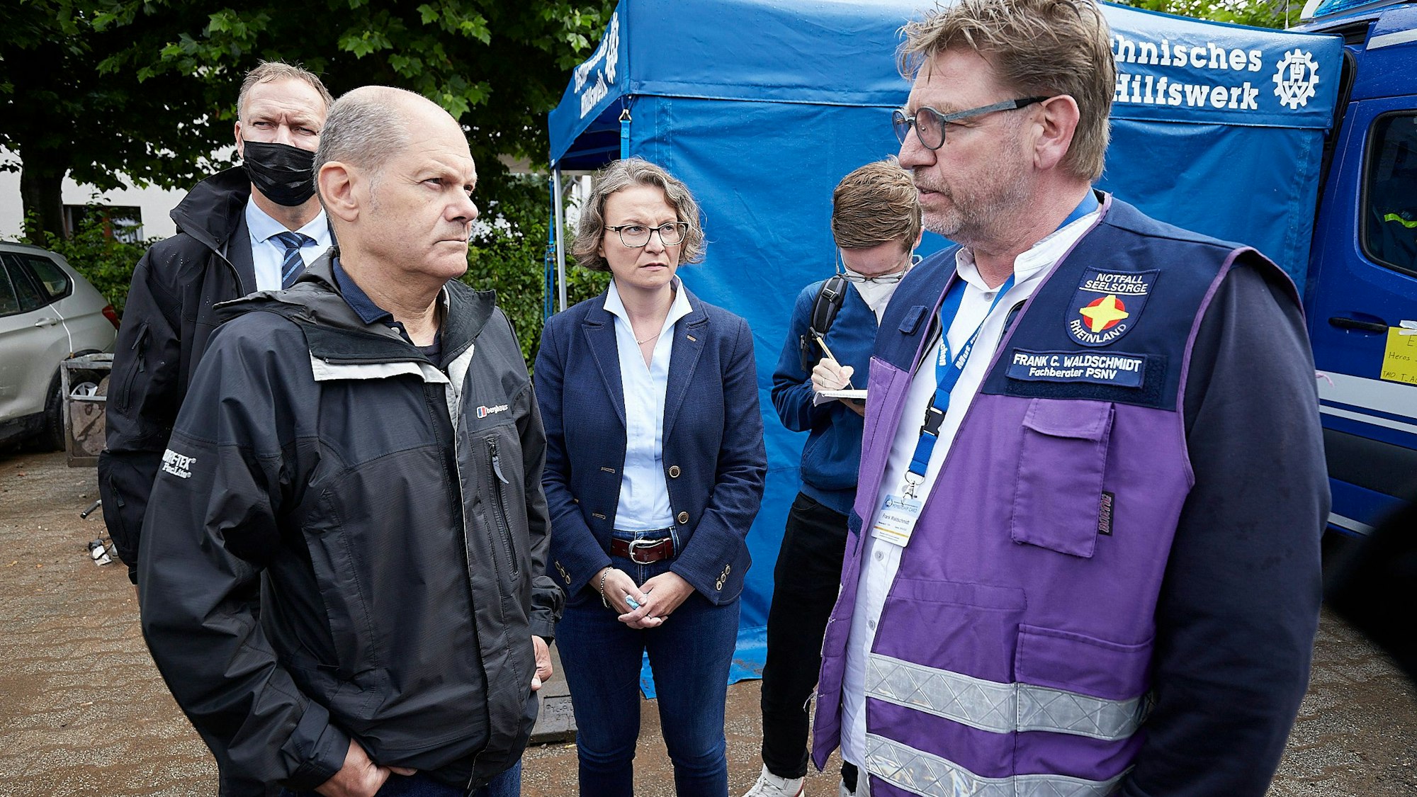 Frank Waldschmidt (r.) trägt die lilafarbene Weste, die ihn als Notfallseelsorger kennzeichnet. Nach der Flutkatastrophe in Gemünd informiert er Olaf Scholz und Ina Scharrenbach über diese Arbeit.