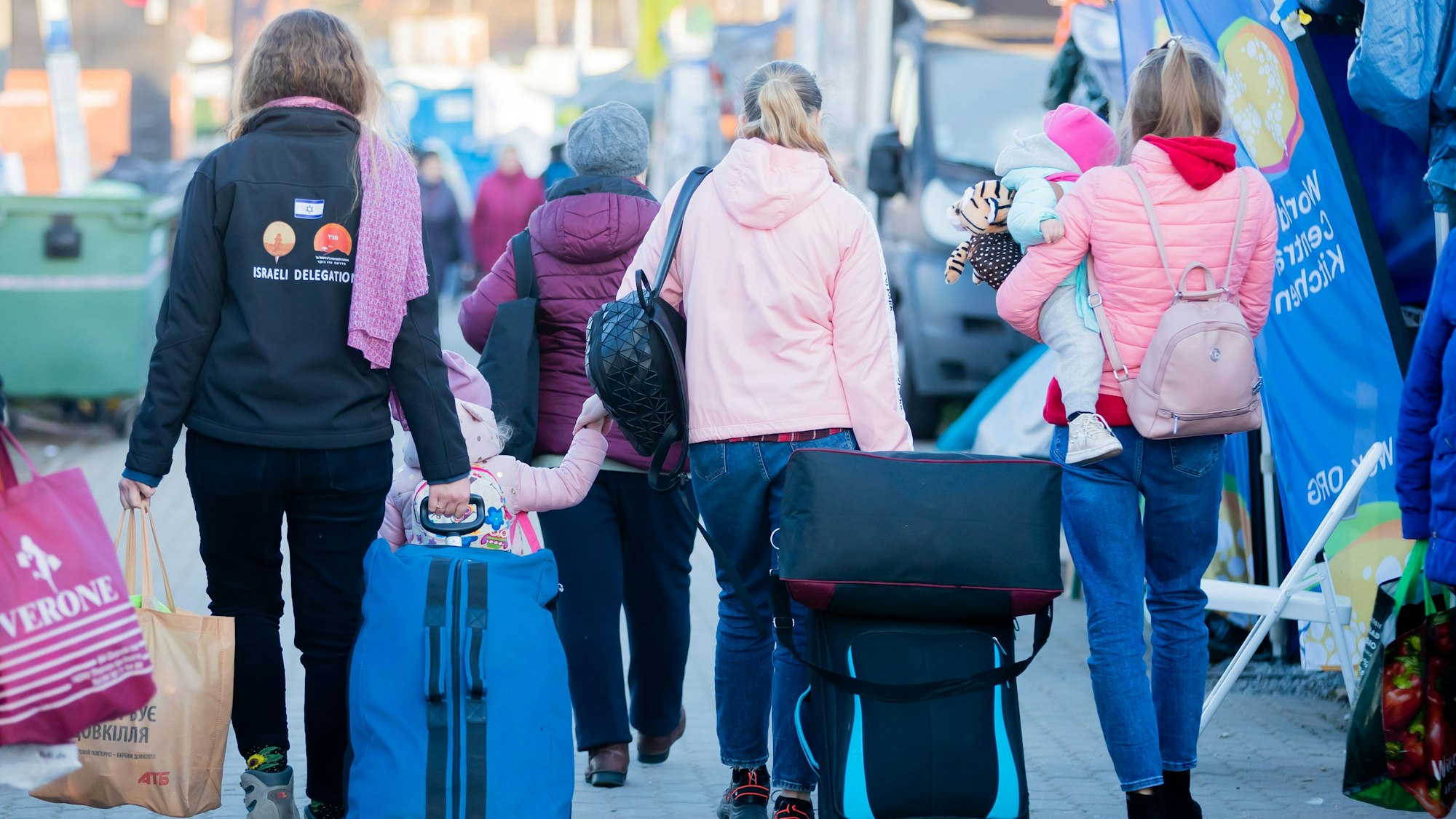 Frauen und Kinder, die aus der Ukraine geflohen sind, werden am Grenzübergang kurz hinter der ukrainischen Grenze, auf polnischer Seite, von einer freiwilligen Helferin (l.) begleitet. (Symbolbild)