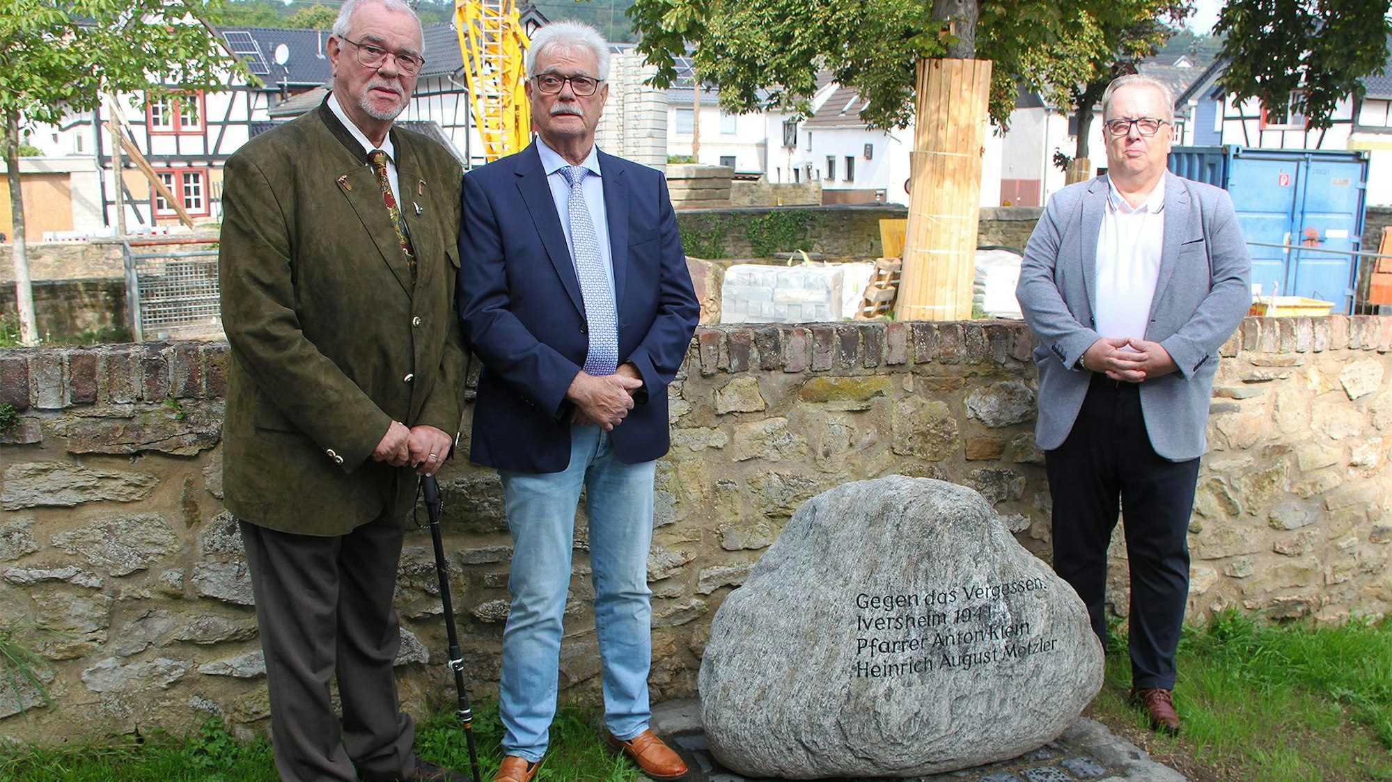 Neben dem Gedenkstein, der an Heinrich-August Metzler und Anton Klein erinnert, stehen Friedel und Georg Metzler (v.l.) sowie Lothar Radermacher.