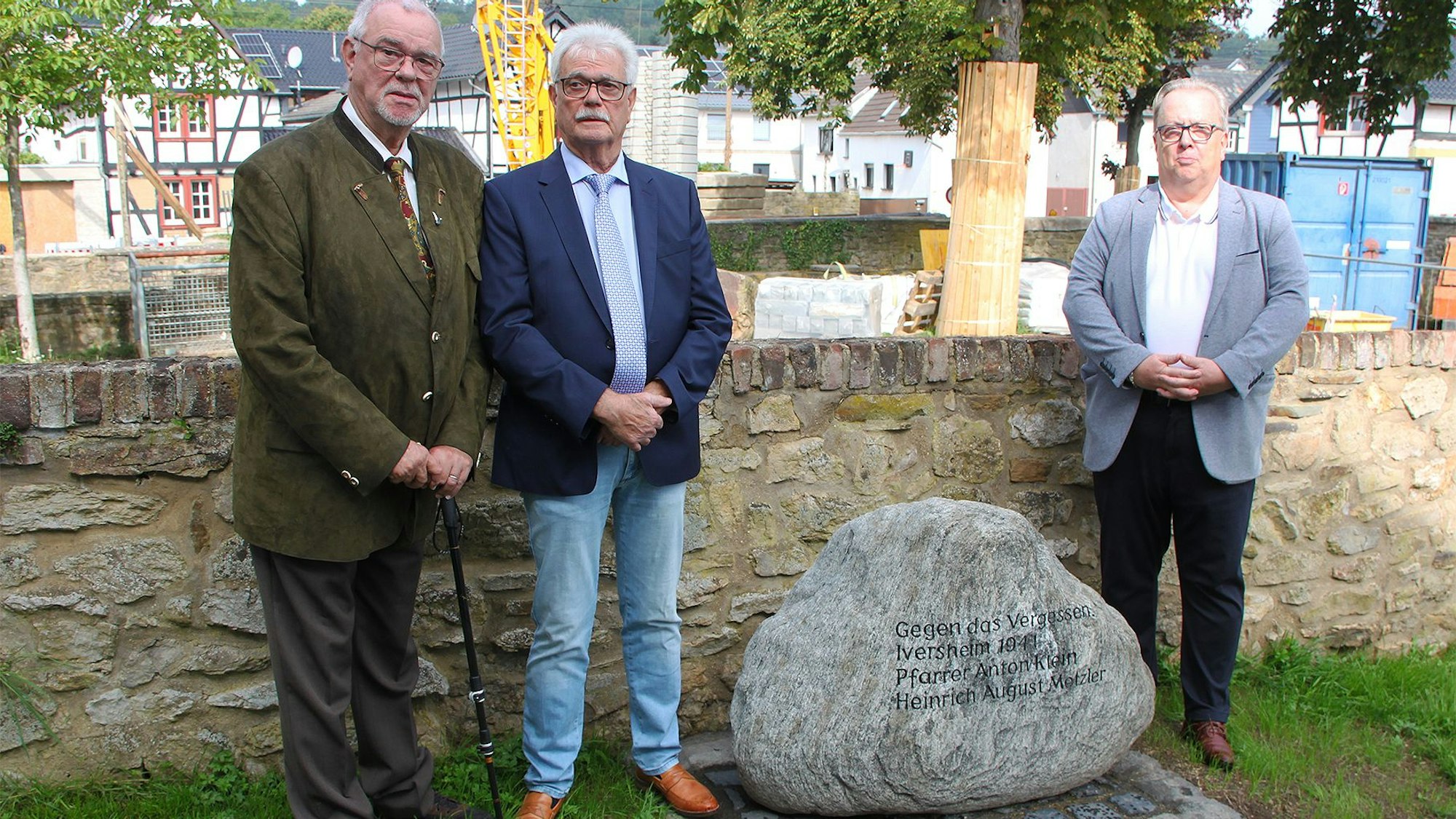 Neben dem Gedenkstein, der an Heinrich-August Metzler und Anton Klein erinnert, stehen Friedel und Georg Metzler (v.l.) sowie Lothar Radermacher.