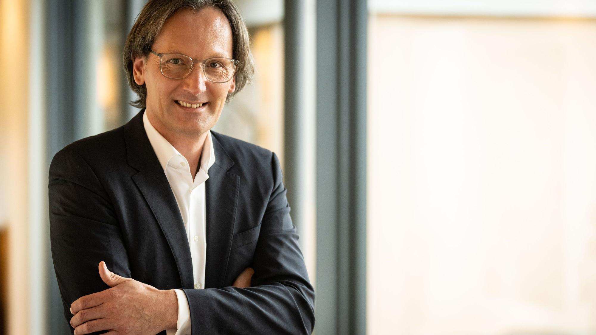 Der neue Generaldirektor des Grandhotel Schloss Bensberg steht mit verschränkten Armen an einem Fenster.