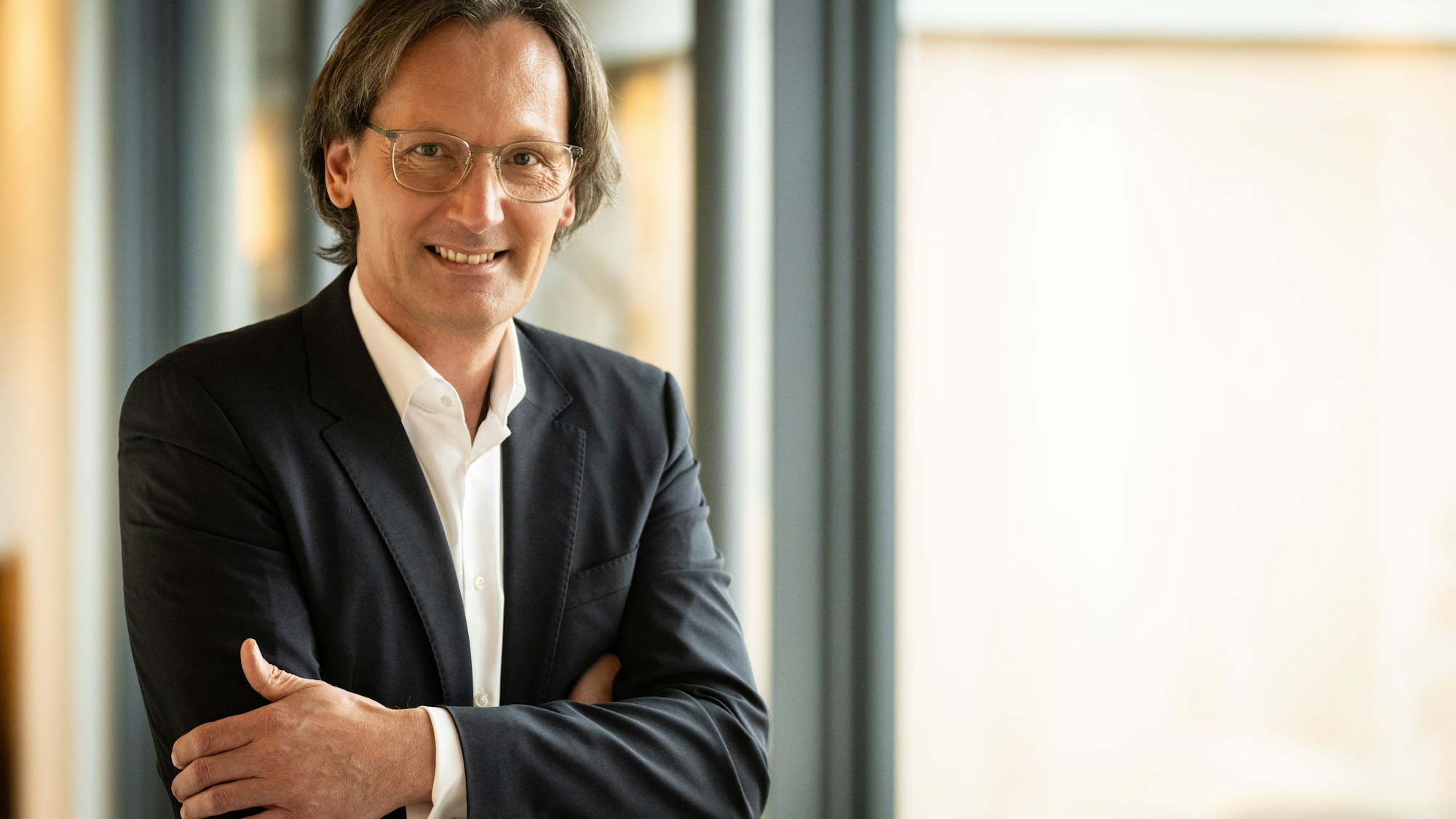 Der neue Generaldirektor des Grandhotel Schloss Bensberg steht mit verschränkten Armen an einem Fenster.