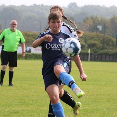Eine Fußballerin schaut auf den Ball.
