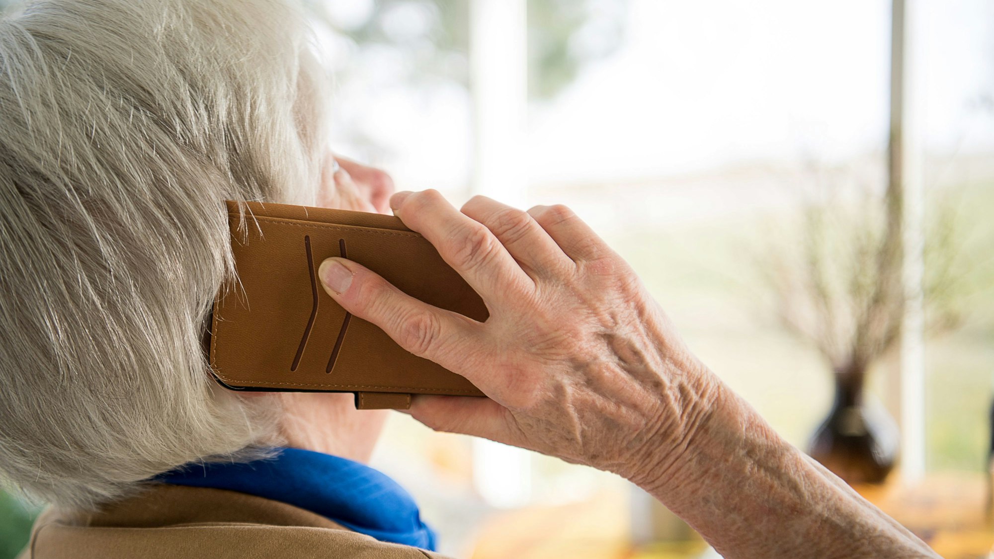 ARCHIV - 06.03.2018, Baden-Württemberg, Mühlacker: Eine Seniorin telefoniert mit ihrem Smartphone.