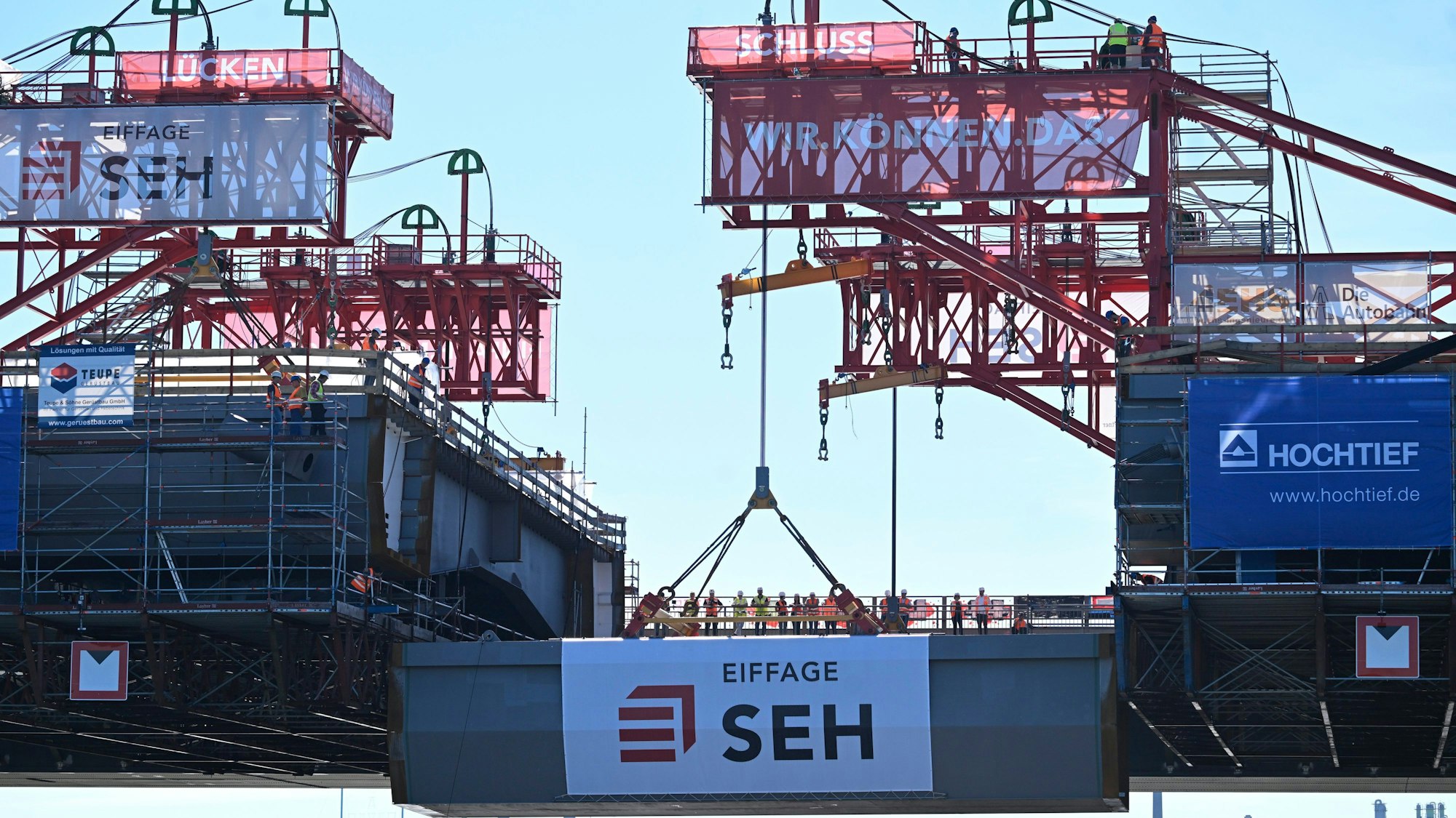 Leverkusen: Ein Kran hebt das letzte Bauteil zur "Brückenhochzeit" an den Neubau der Leverkusener Rheinbrücke. Ungefähr sechs Jahre nach Beginn der Arbeit ist die Brücke nun über dem Rhein verbunden. Nach Fahrbahneinbringung und diversen Sicherheitsvorkehrungen wird die Brücke ca Januar 2024 für den Verkehr freigegeben. Dann wird die alte marode Brücke abgerissen und mit den Arbeiten zum zweiten Teil gestartet. Völlige Baufertigstellung soll dann 2027 sein. Foto: Roberto Pfeil/dpa +++ dpa-Bildfunk +++