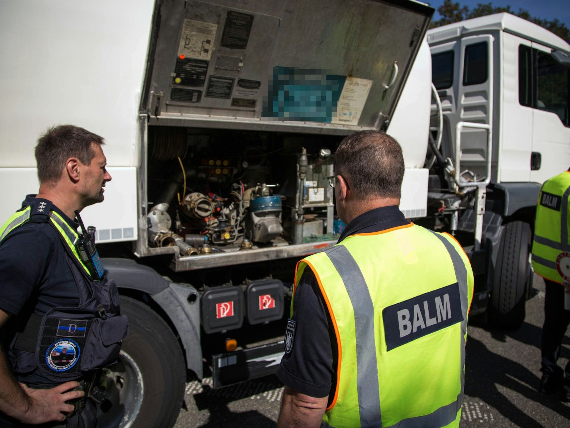 Das Bild zeigt zwei Beamte an einem Lastwagen.