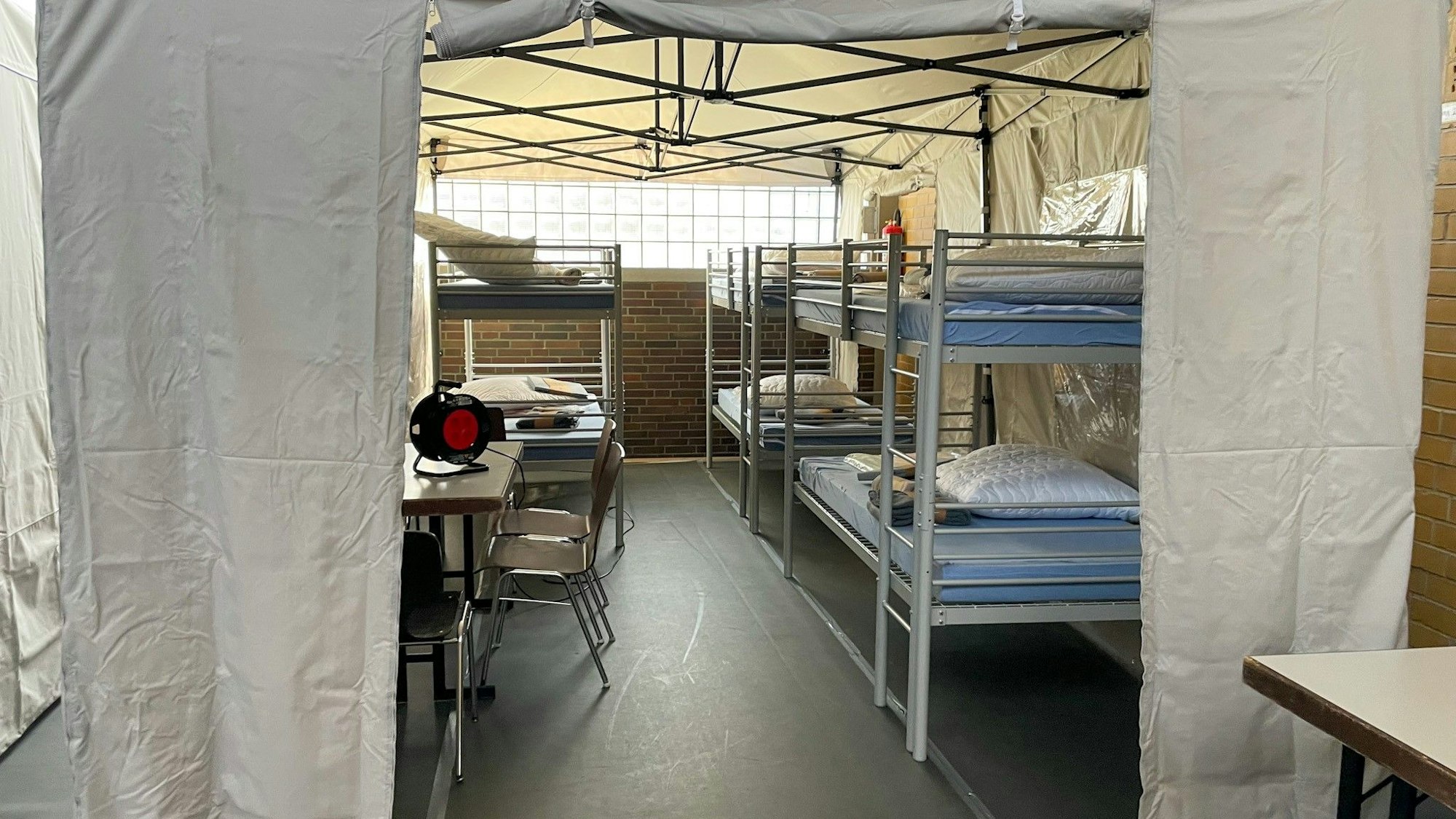 Auf dem Foto sind unter anderem Etagenbetten hinter einem Sichtschutz zu sehen.