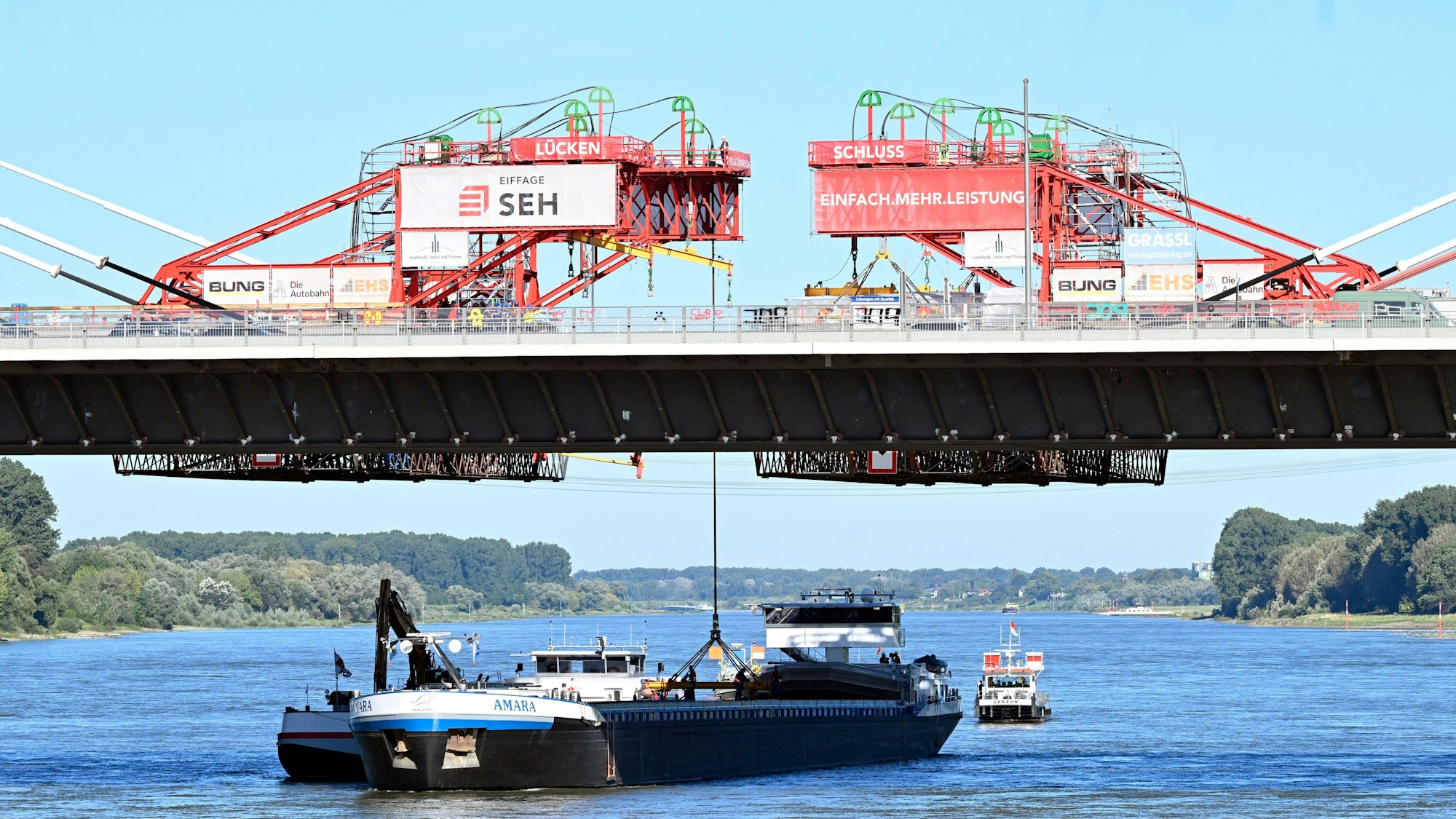 05.09.2023, Nordrhein-Westfalen, Leverkusen: Ein Kran hebt das letzte Bauteil zur «Brückenhochzeit» an den Neubau der Leverkusener Rheinbrücke. Ungefähr sechs Jahre nach Beginn der Arbeit ist die Brücke nun über dem Rhein verbunden. Nach Fahrbahneinbringung und diversen Sicherheitsvorkehrungen wird die Brücke ca Januar 2024 für den Verkehr freigegeben. Dann wird die alte marode Brücke abgerissen und mit den Arbeiten zum zweiten Teil gestartet. Völlige Baufertigstellung soll dann 2027 sein. Foto: Roberto Pfeil/dpa +++ dpa-Bildfunk +++