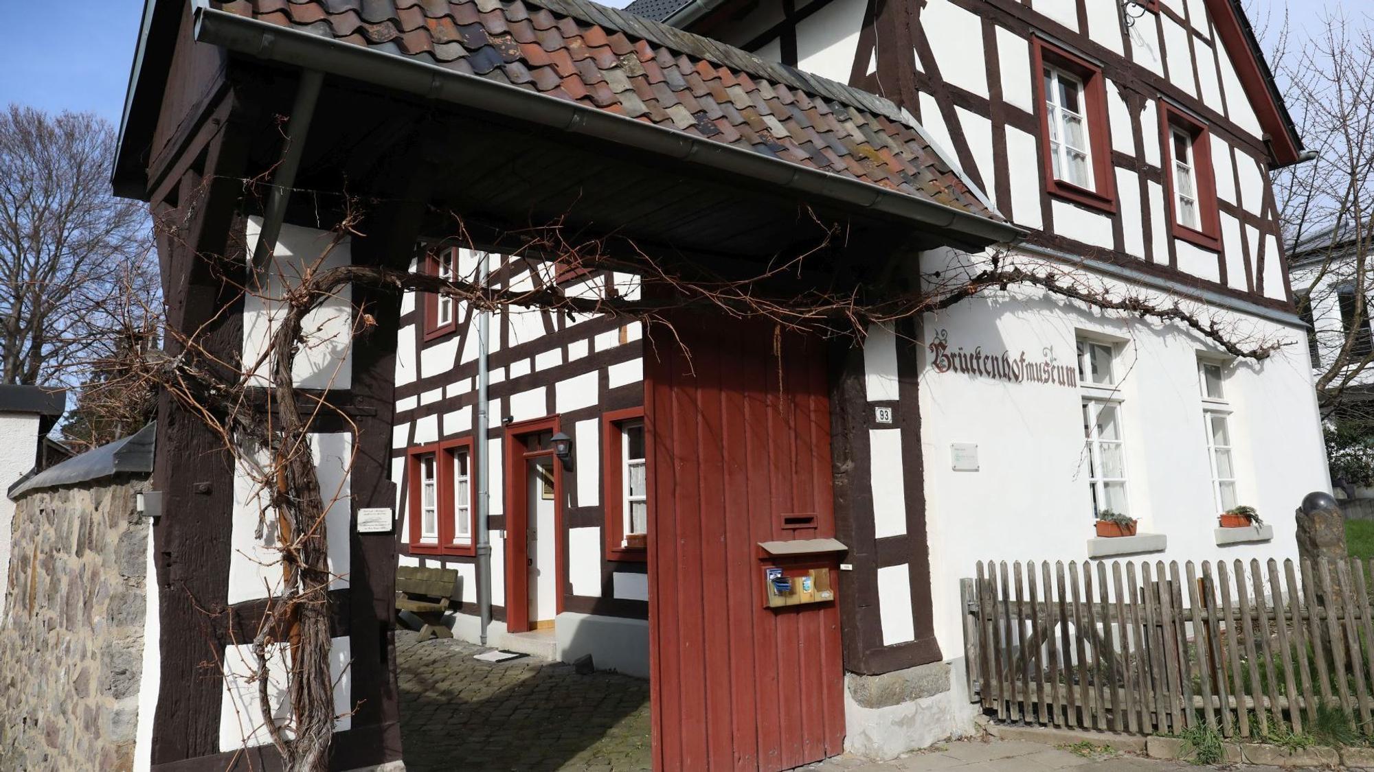 Ein Fachwerkhaus mit roter Fenstereinfassung und rotem Tor.