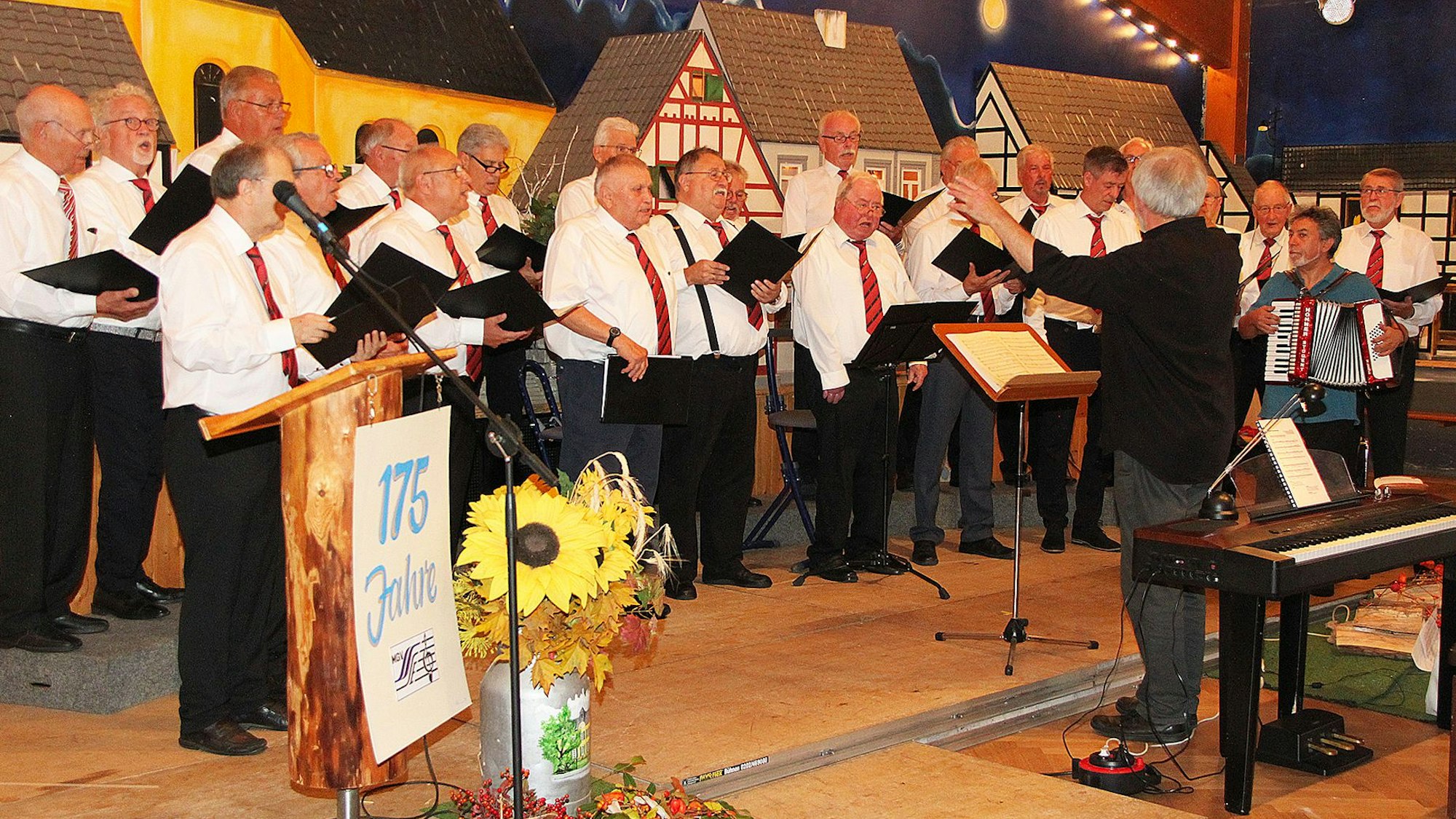 Der Männergesangverein Steinbach-Erft steht auf der Bühne des Dorfgemeinschaftshauses Palmersheim.