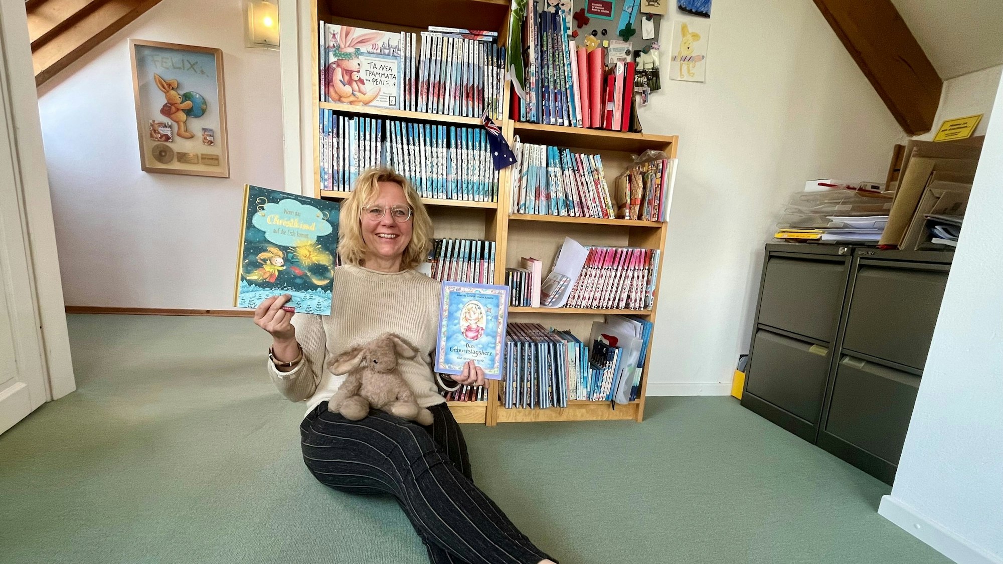 Annette Langen feiert ihr 30. Dienstjubiläum als Kinderbuchautorin, in der Hand ihr erstes (rechts) und jüngstes (links) Buch