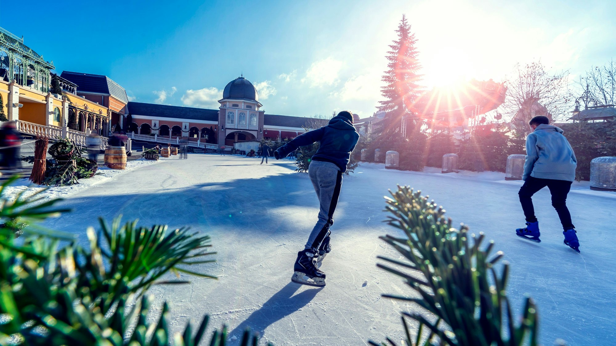 Personen fahren mit Schlittschuhen auf einer großen Eisbahn im Phantasialand.