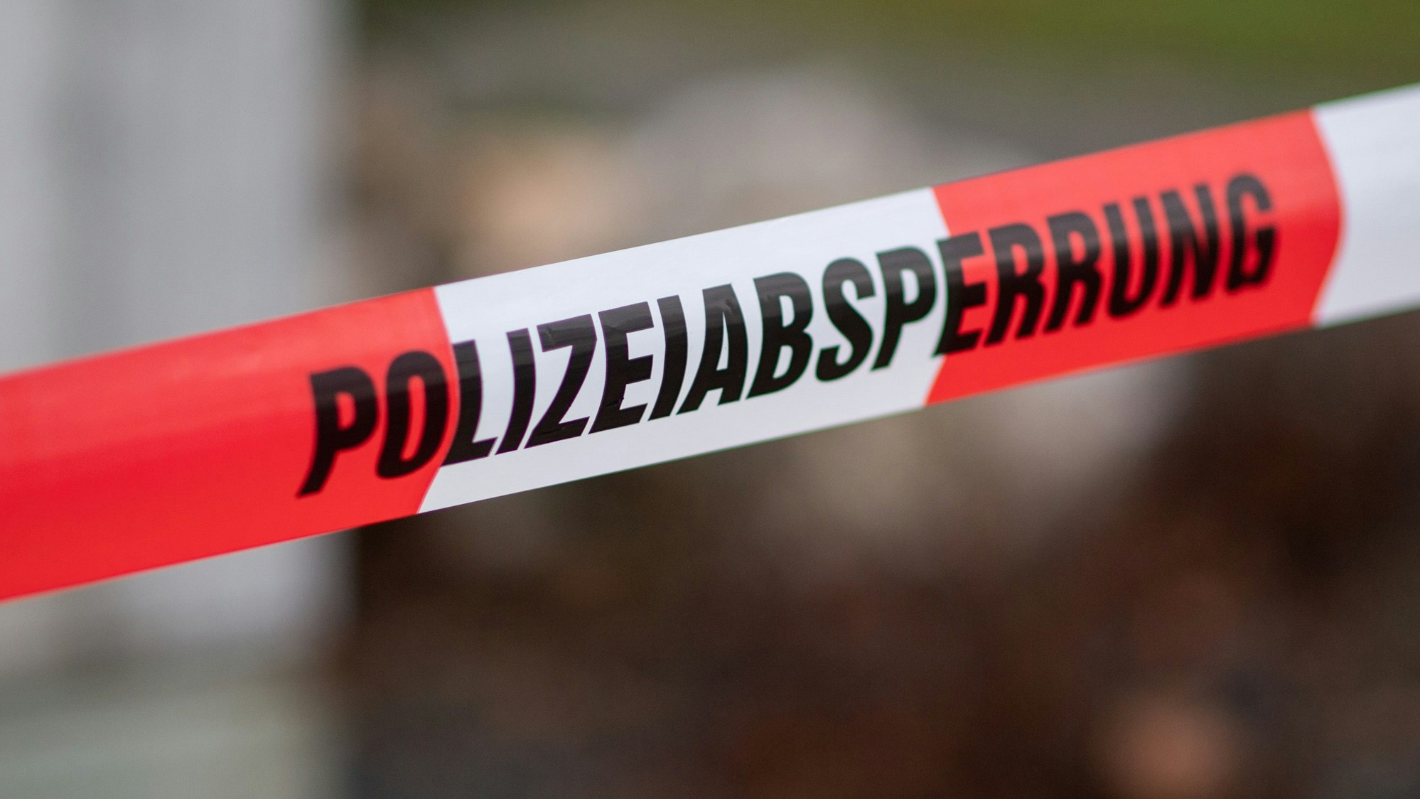 Das Bild zeigt rot-weißes Absperrband mit dem Schriftzug Polizeiabsperrung.