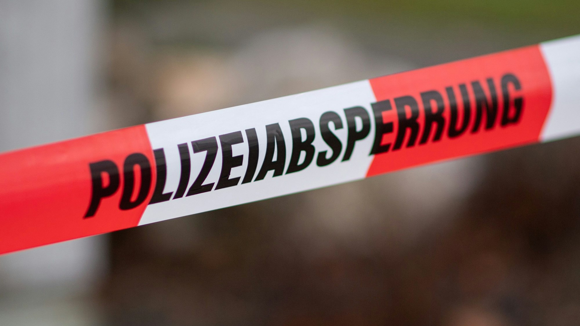 Auf einem rot-weißen Flatterband ist der Aufdruck Polizeiabsperrung zu lesen.