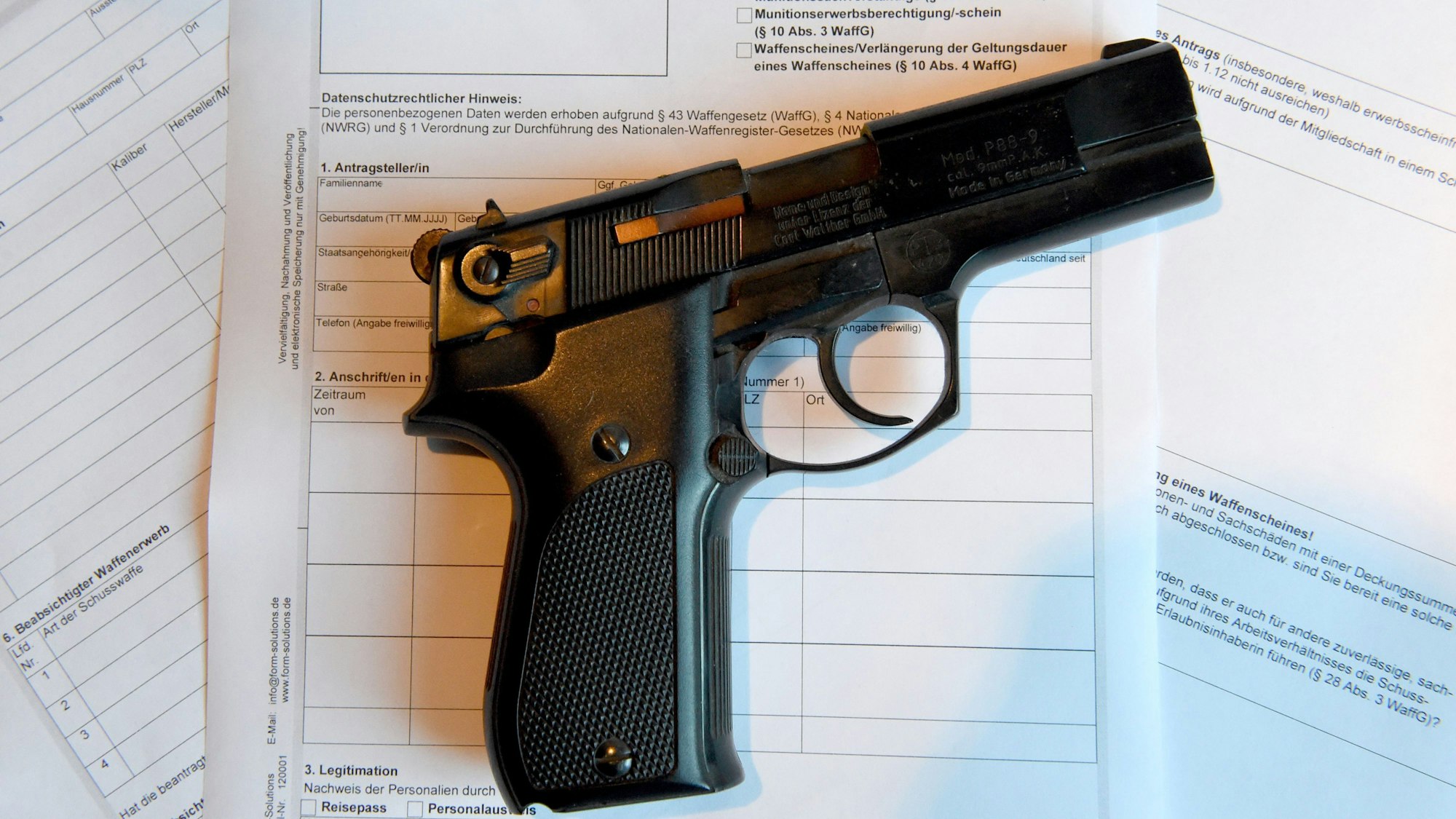 Eine Pistole liegt auf einem Antrag für die Ausstellung eines Waffenscheines.