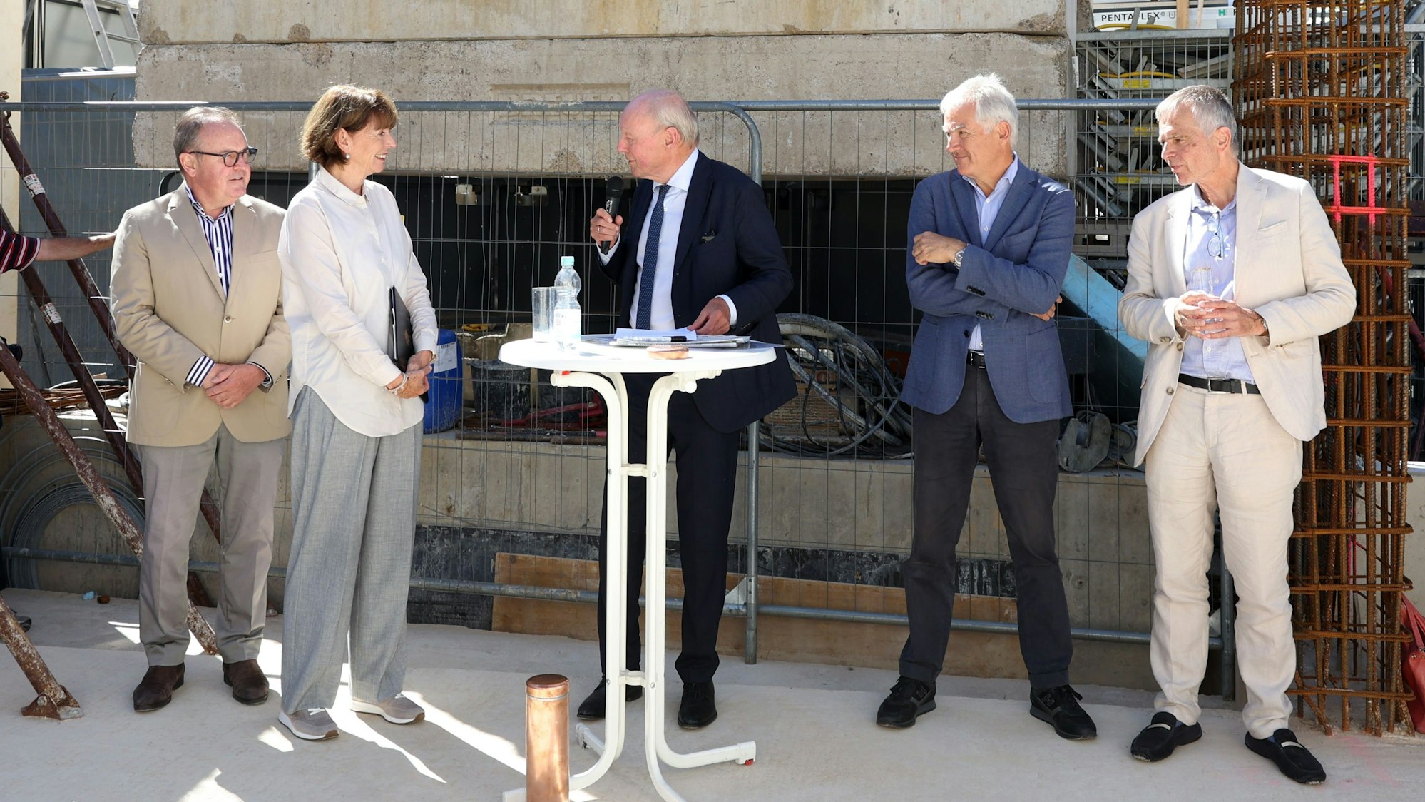 Mehrere Personen stehen auf der Baustelle der neuen Musikschule.