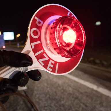 Ein Polizist hält am 03.12.2016 während einer Verkehrskontrolle mit einer Haltekelle Fahrzeuge an.