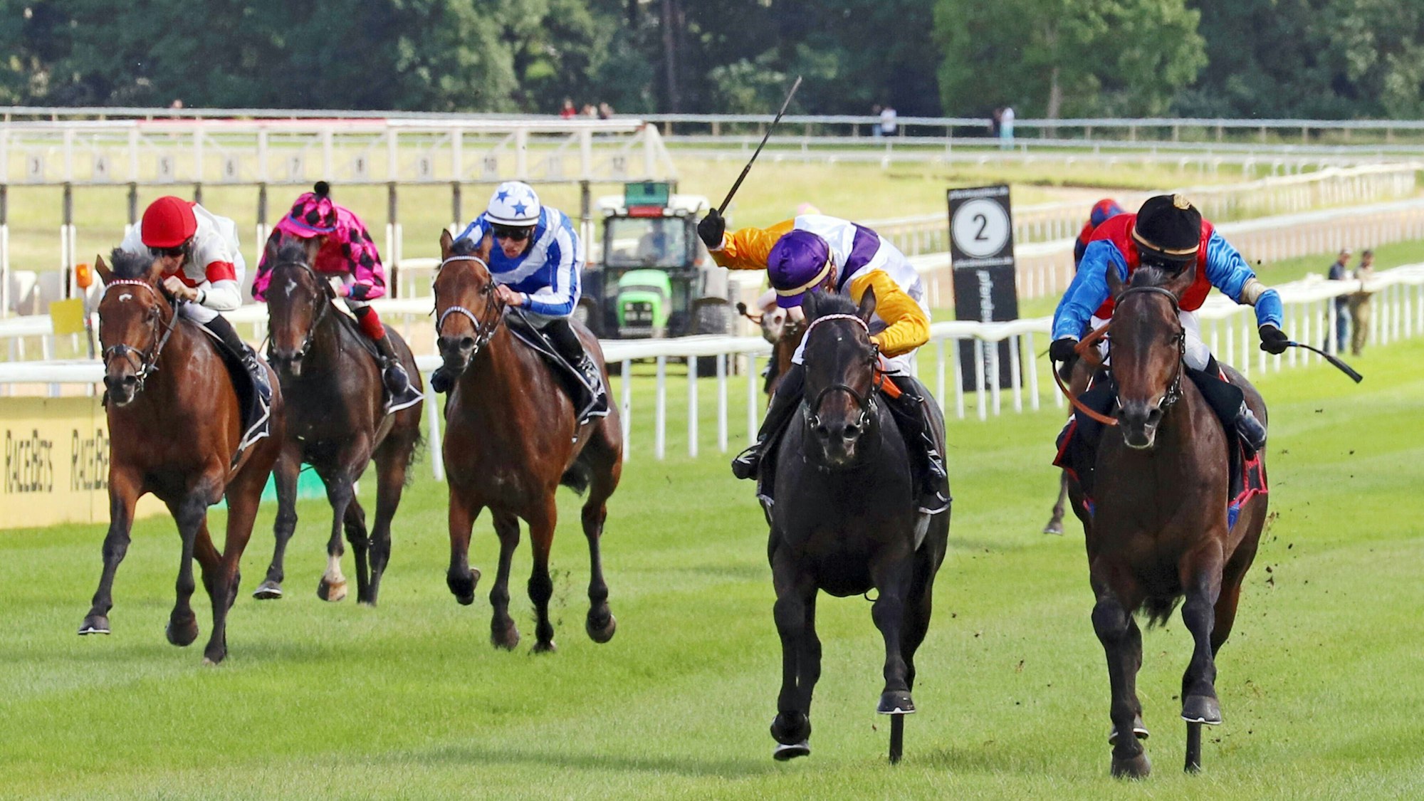 Mehrere Jockeys reiten auf ihren Pferden auf der Galopprennbahn in Weidenpesch.